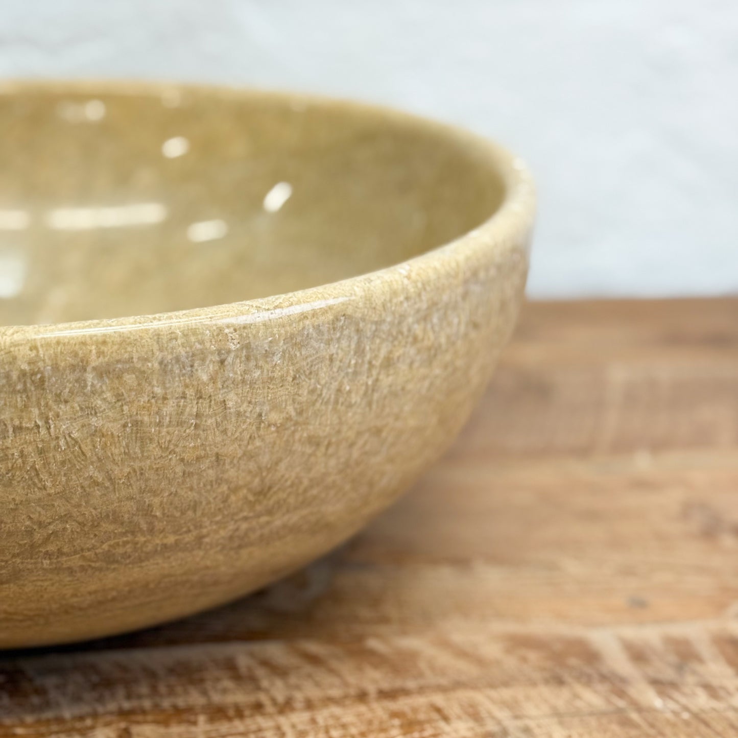 Brown ceramic bowl on a wooden surface with a blurred background