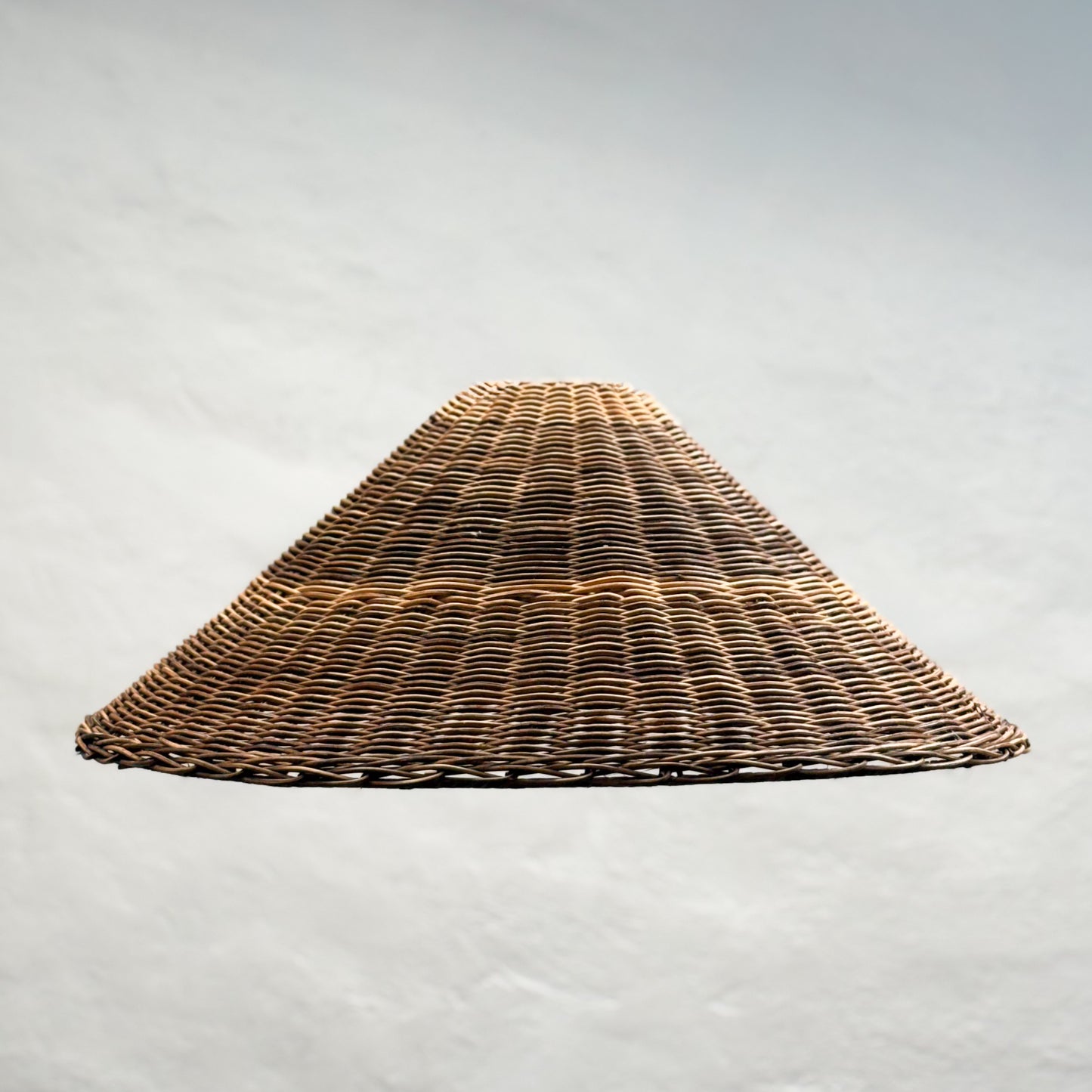 Wicker lampshade on a light gray background