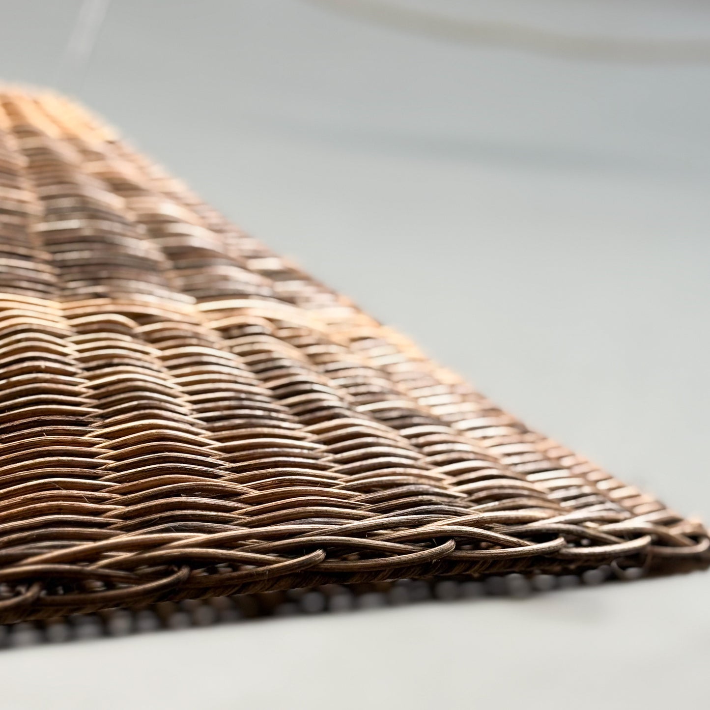 Close-up of a wicker placemat on a light gray surface