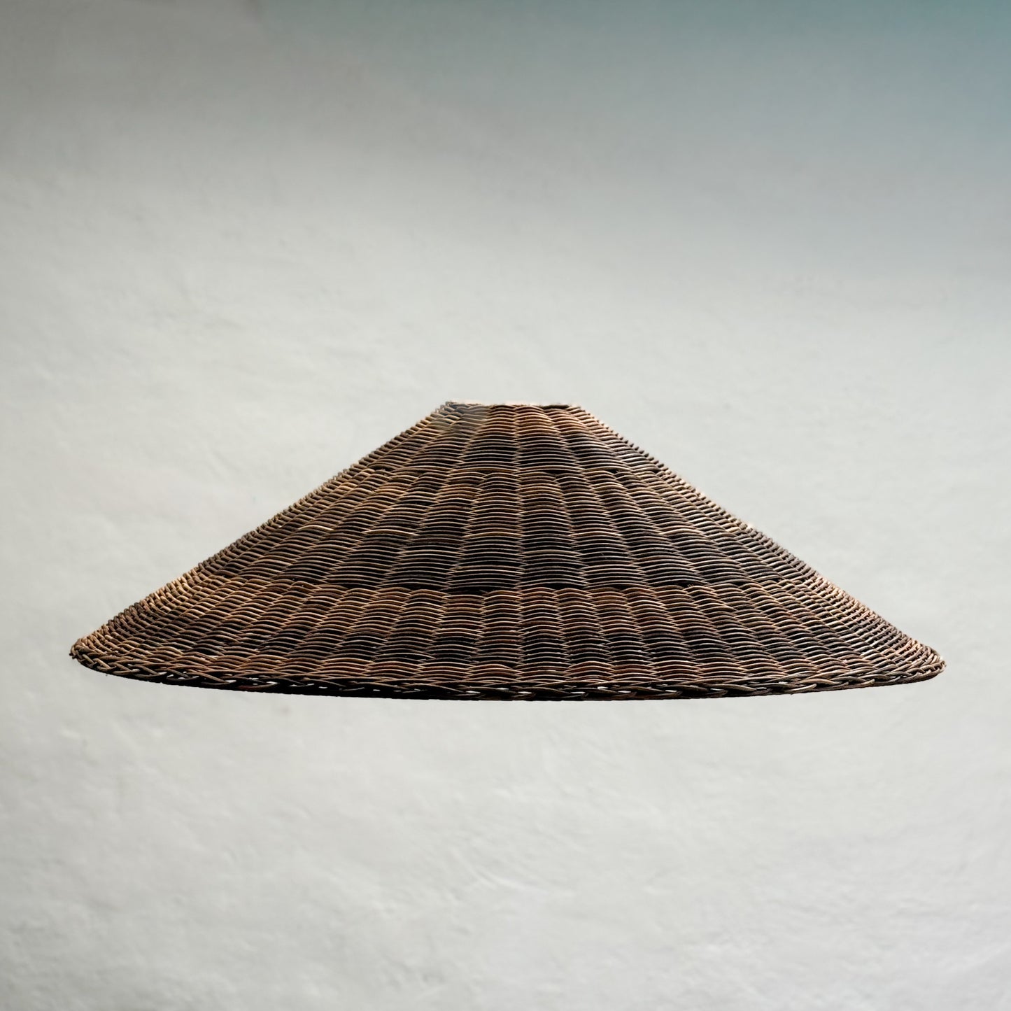 Woven brown lampshade on a light gray background