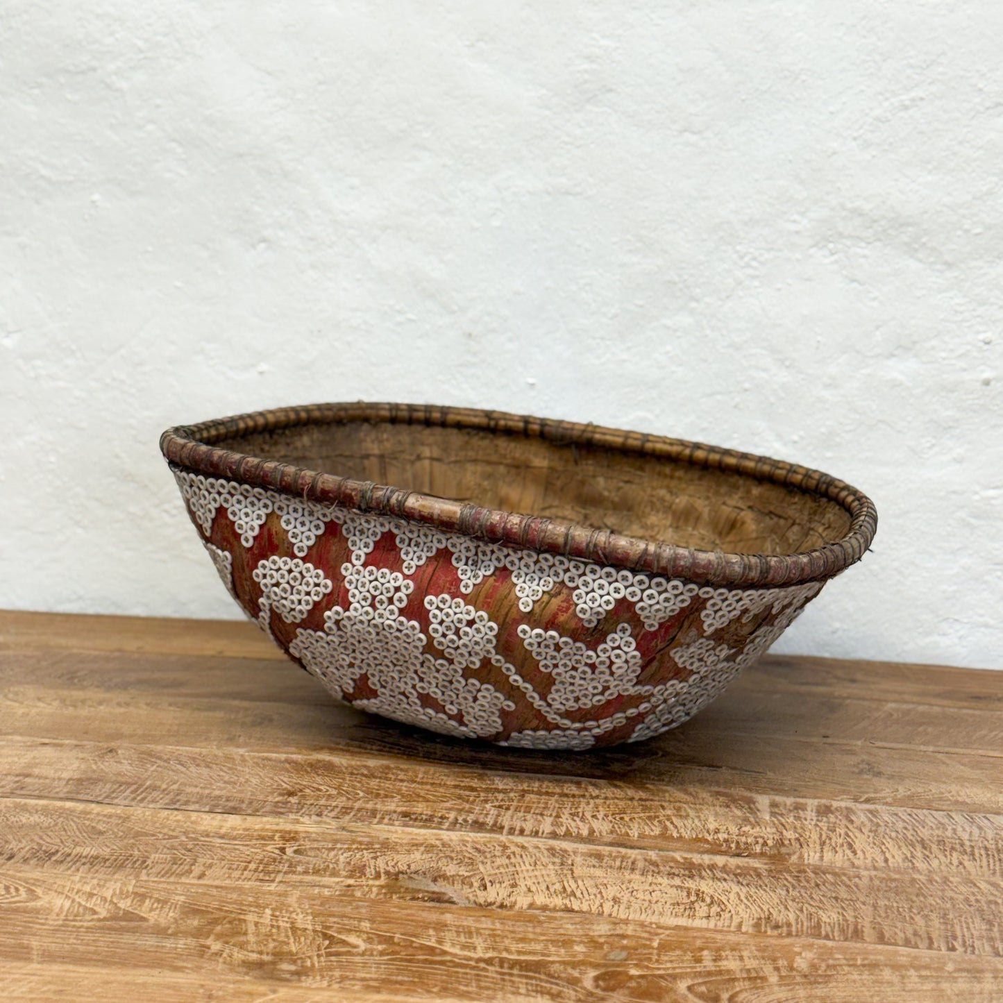 Decorative ceramic bowl with leaf pattern on a wooden surface