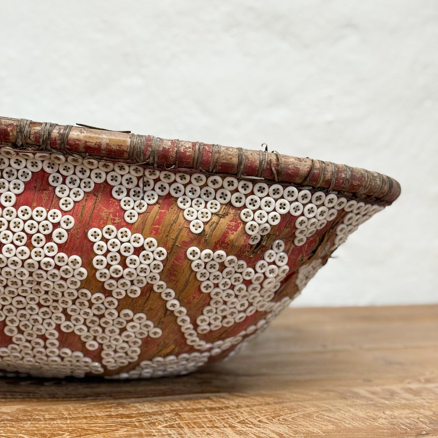 Decorative basket with bead patterns on a wooden surface