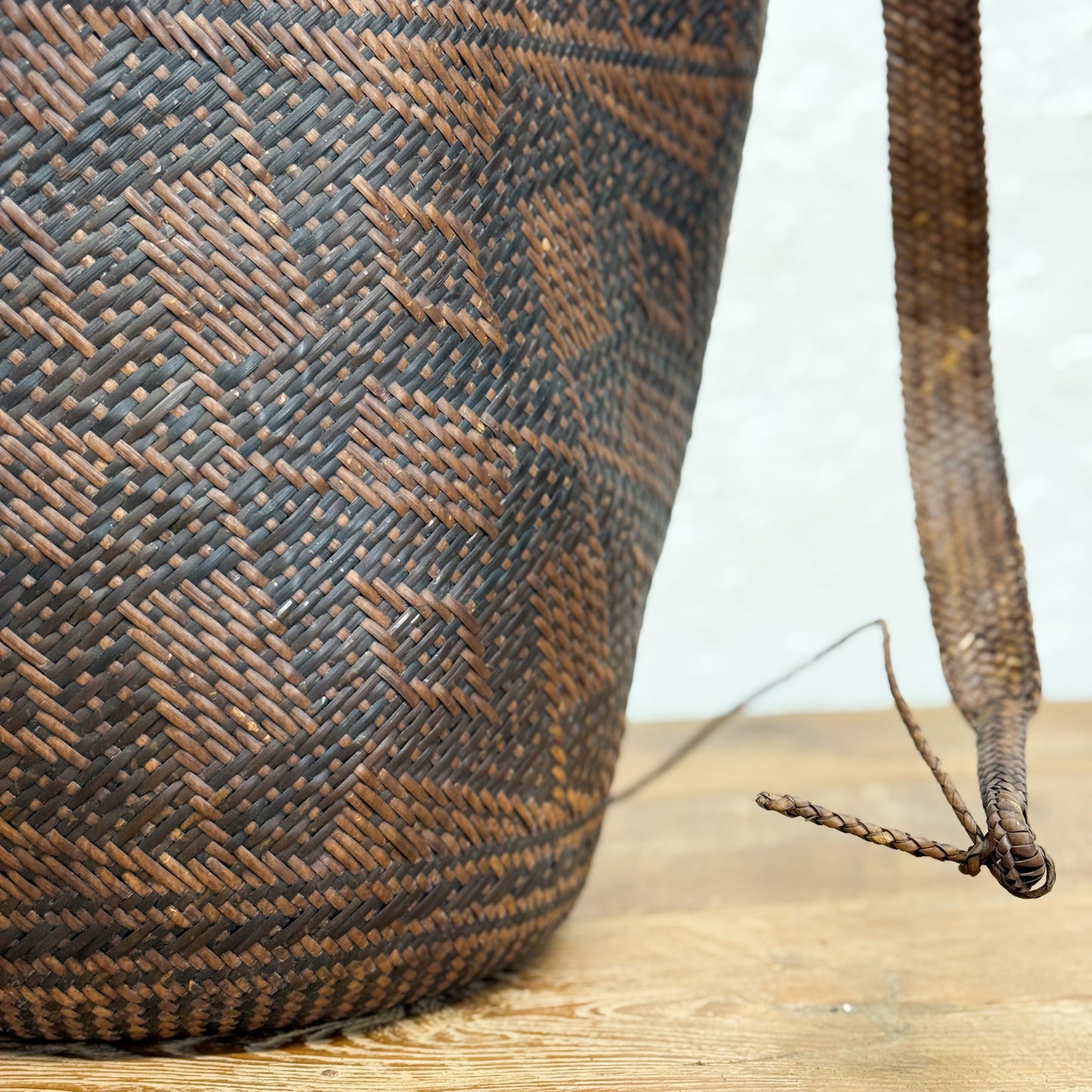 Woven basket with a geometric pattern on a wooden surface