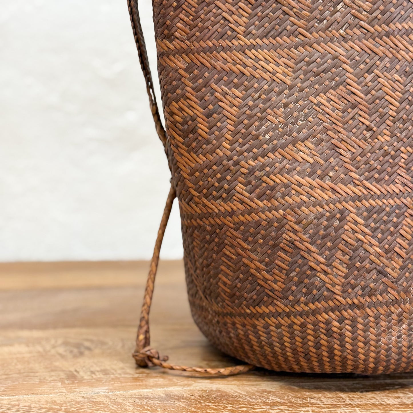 Woven basket with geometric pattern on a wooden surface