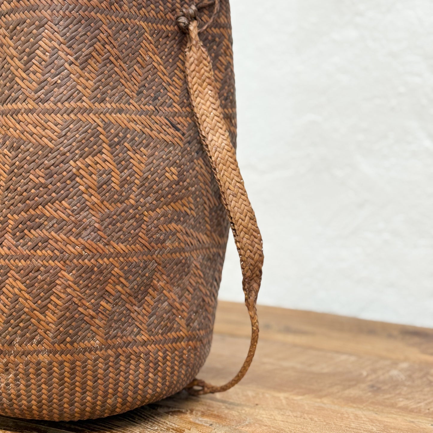 Woven basket with geometric pattern on a wooden surface