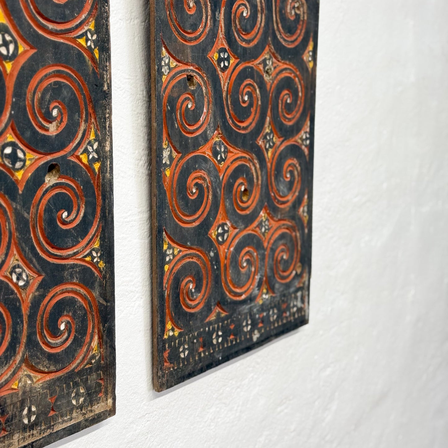 Decorative wooden panels with intricate spiral patterns on a white background