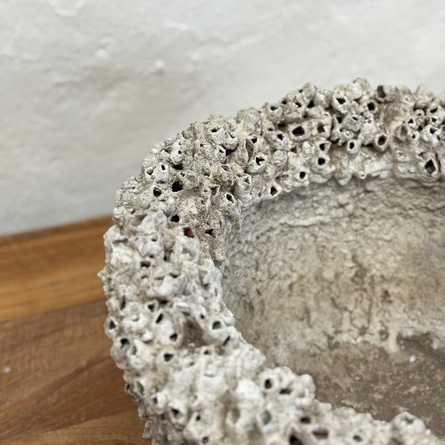 Decorative bowl with textured surface on a wooden surface