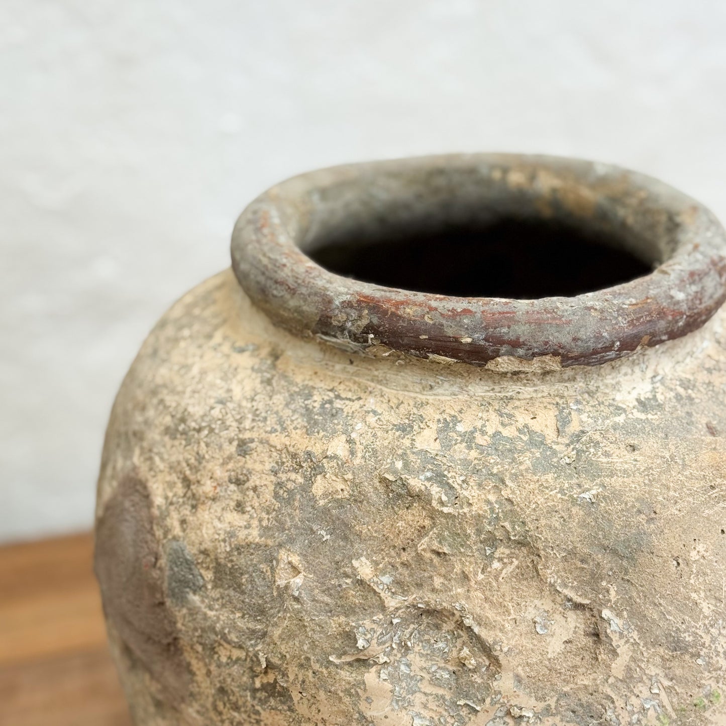 Close-up of an old, textured clay pot with a plain background