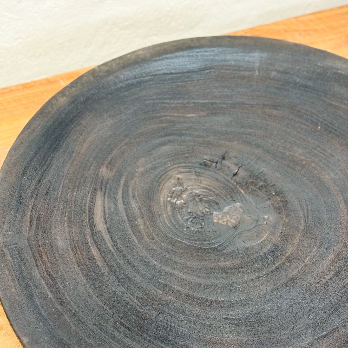 Wooden cutting board with a darkened edge on a light-colored surface