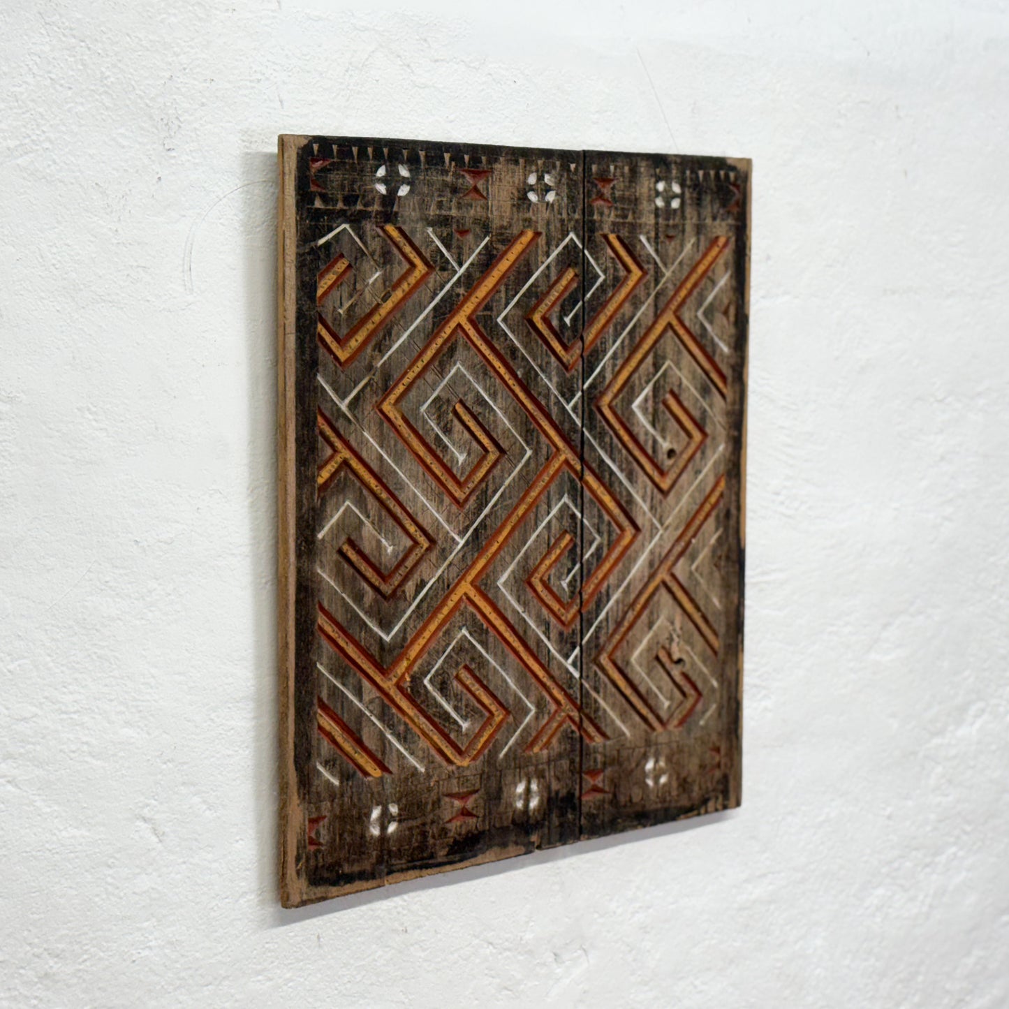 Wooden wall art with geometric pattern on a white background