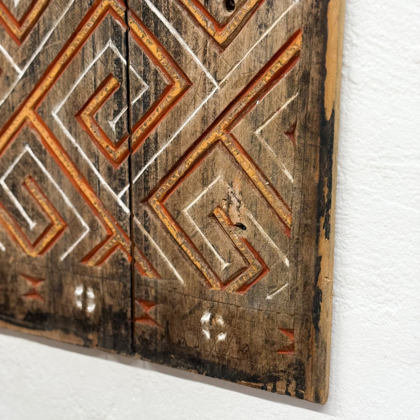 Wooden panel with geometric patterns on a white background