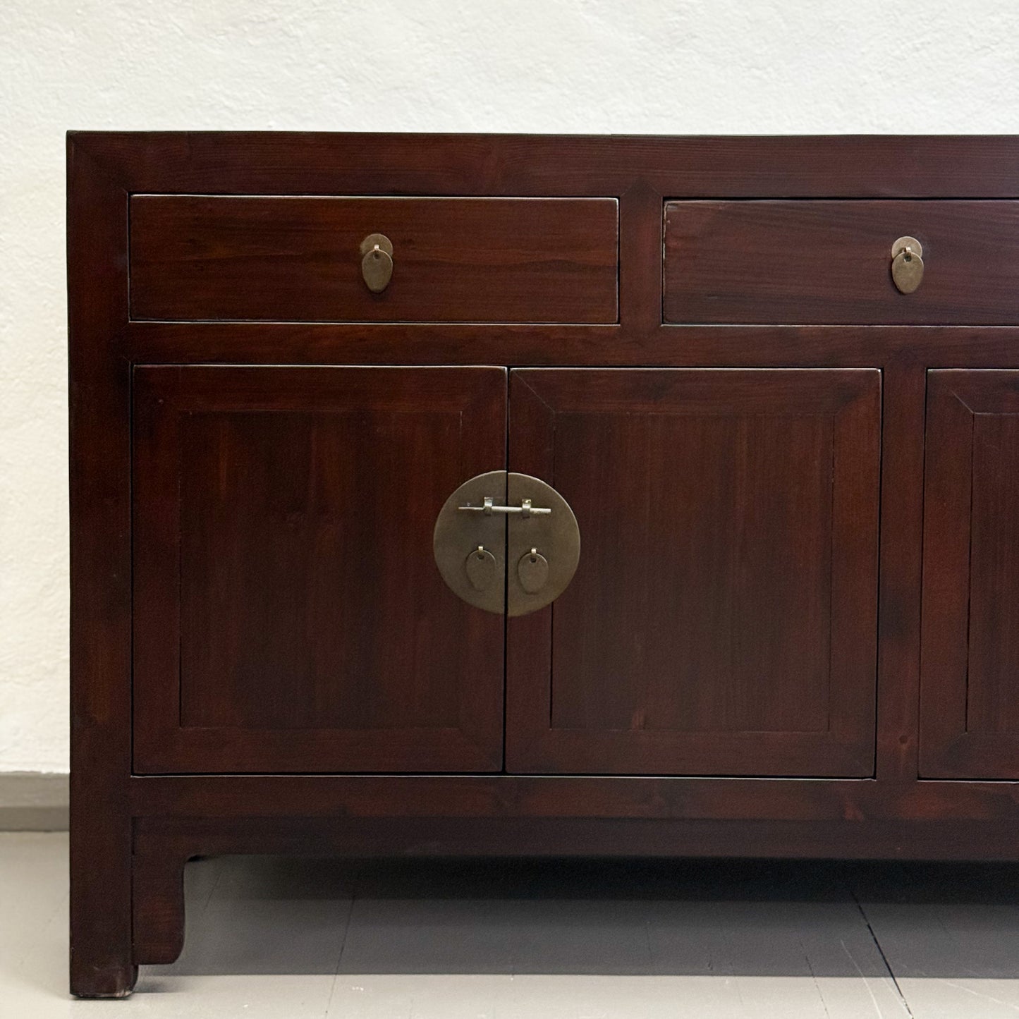 Wooden cabinet with two drawers and a central door on a plain background