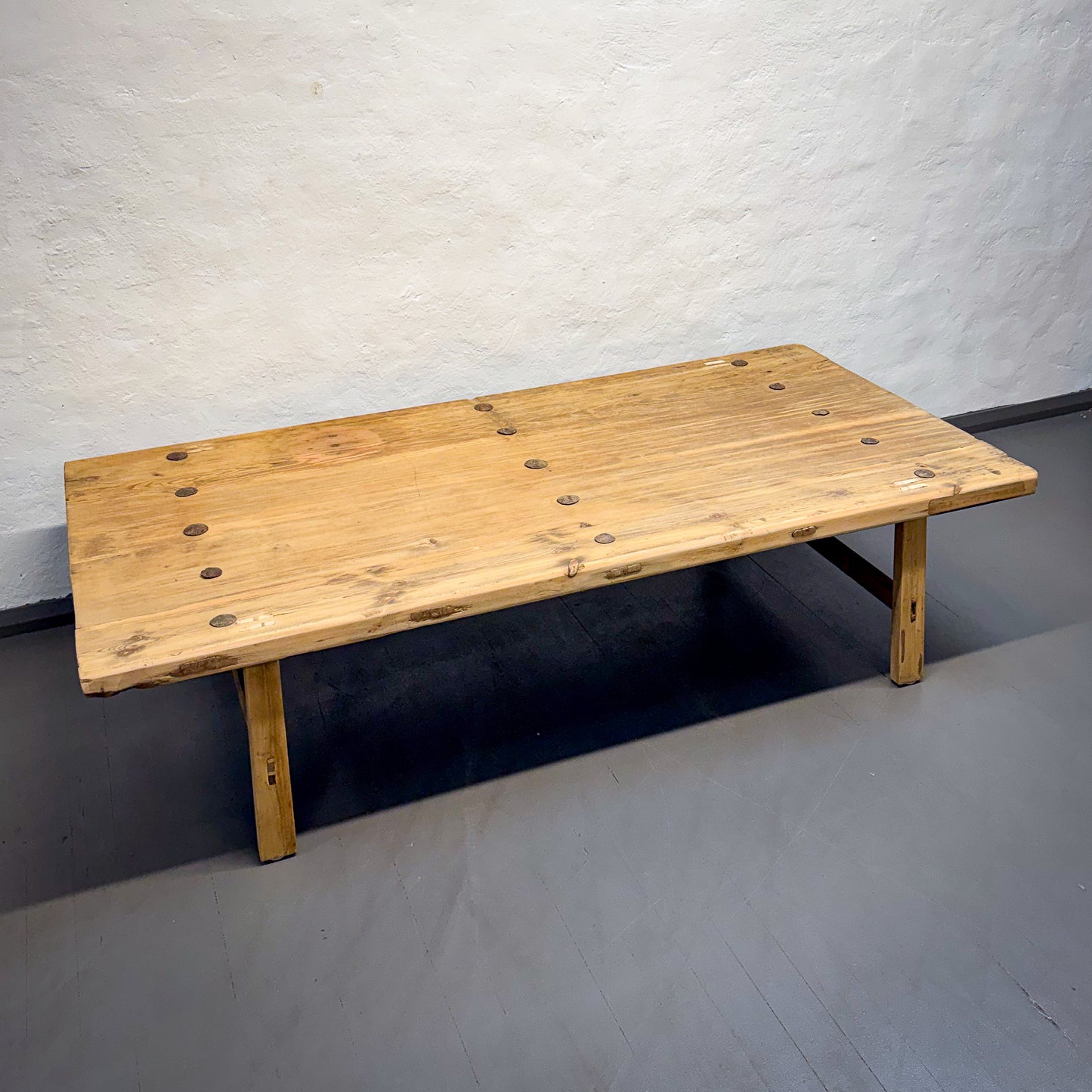 Wooden bench against a plain wall