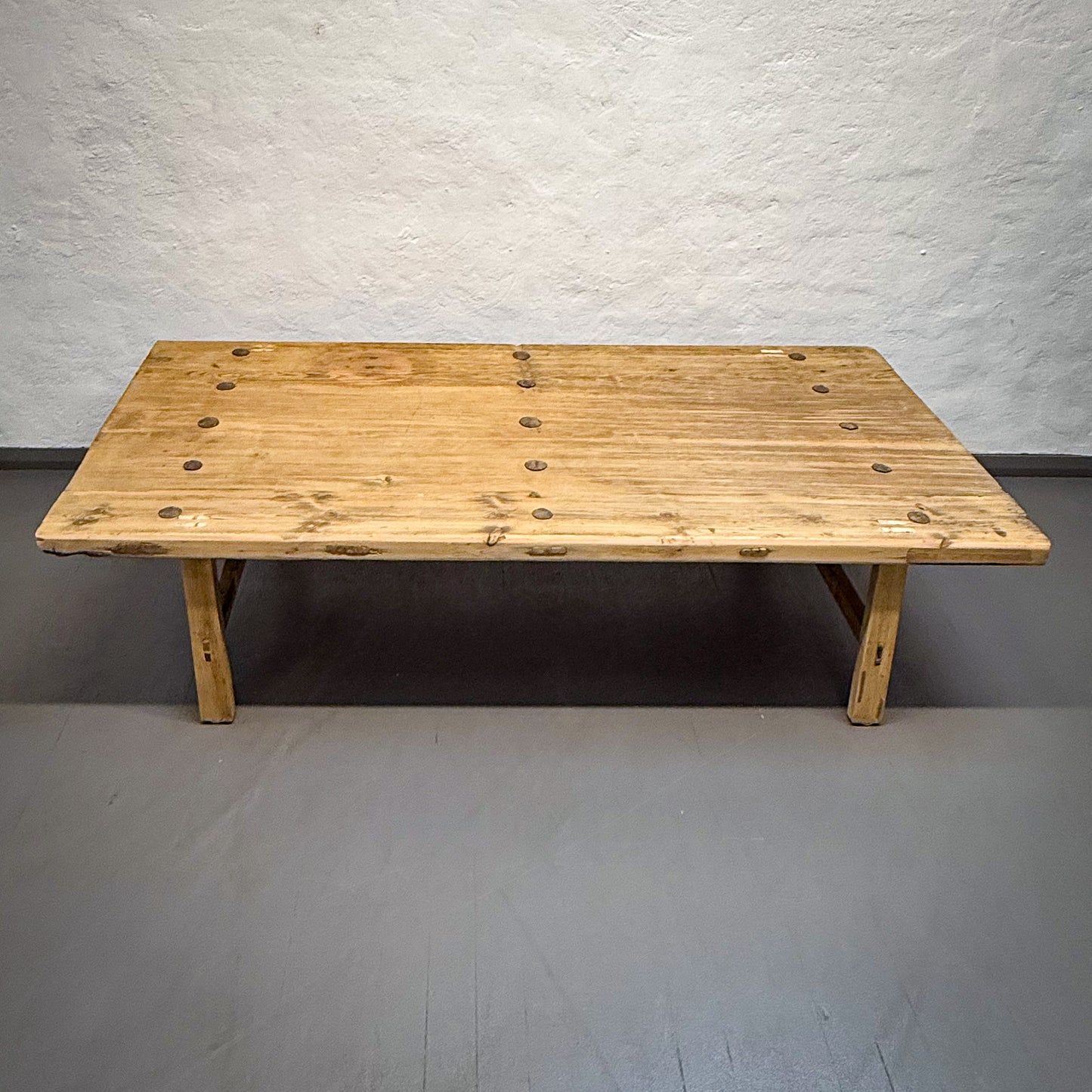 Wooden table against a plain wall