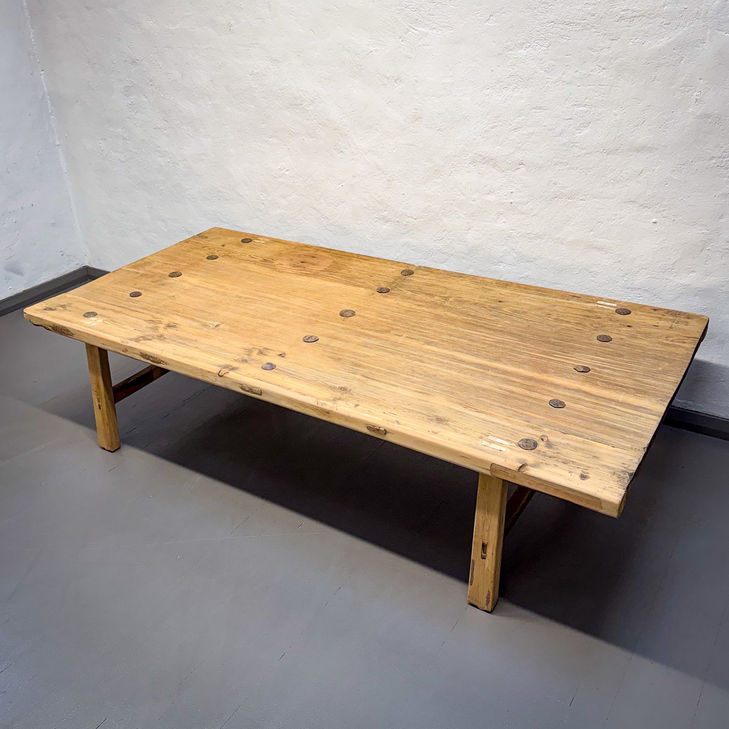 Wooden bench against a plain wall