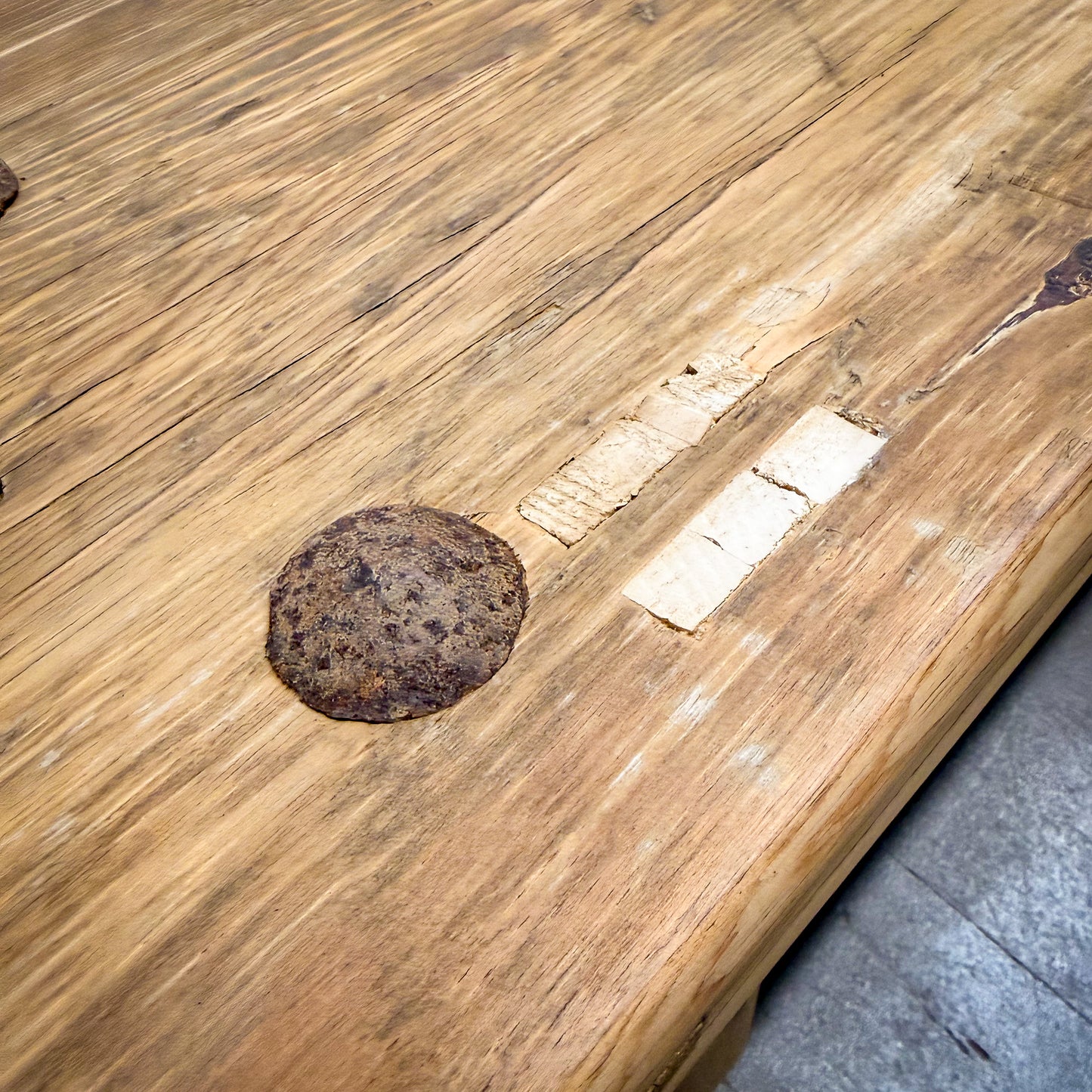 Wooden surface with a large hole and embedded metal object
