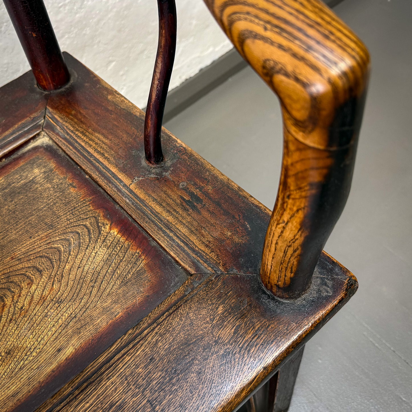 Close-up of a wooden chair with a worn surface on a plain background