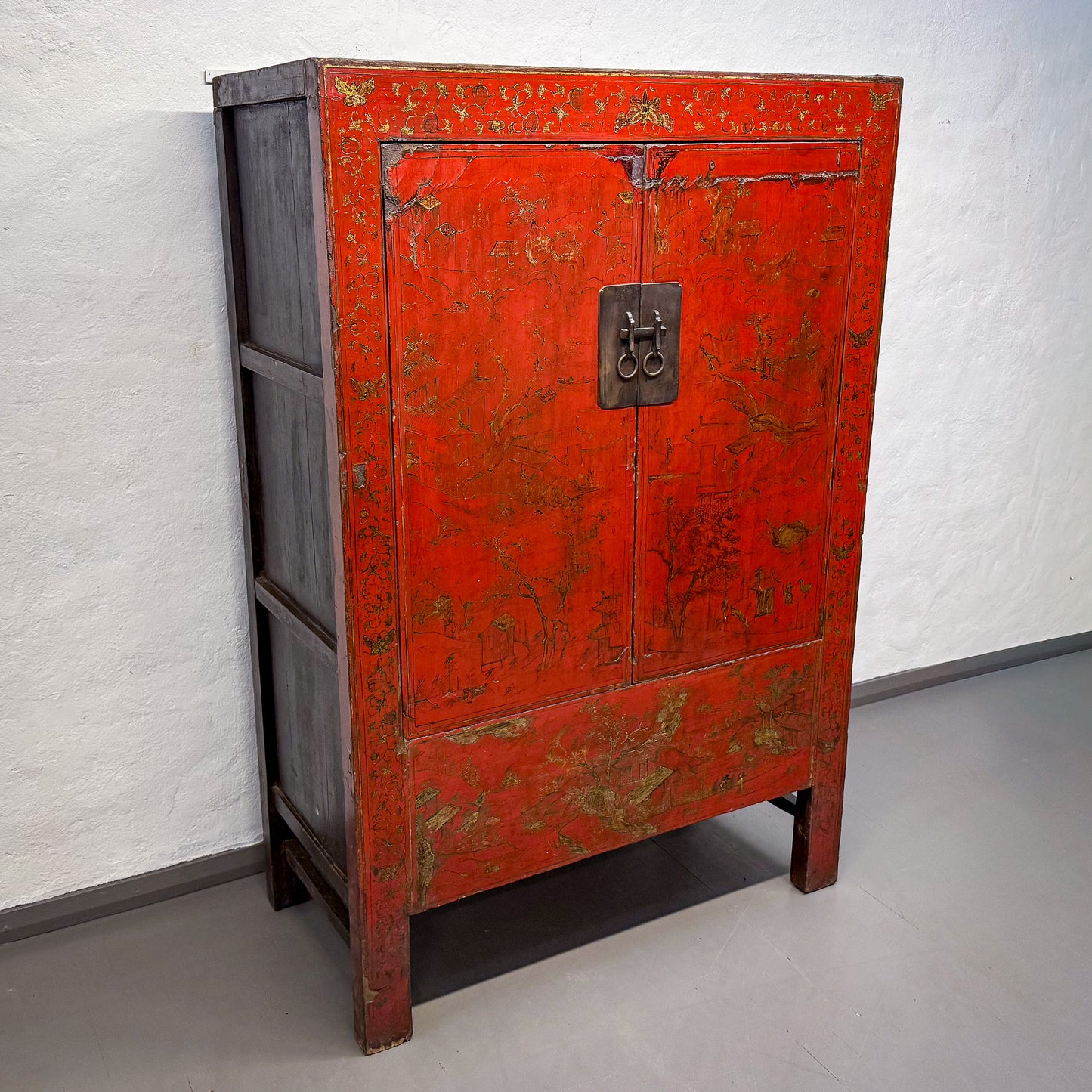 Vintage red cabinet with brass handle on a white background