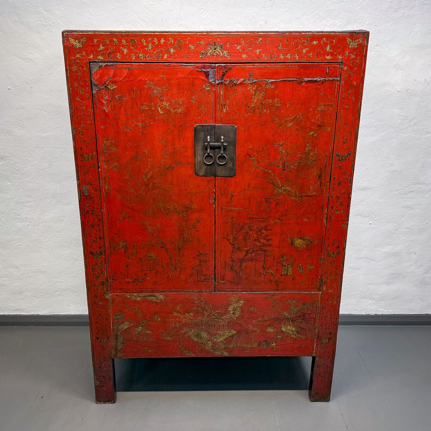 Red vintage cabinet with gold accents on a white background