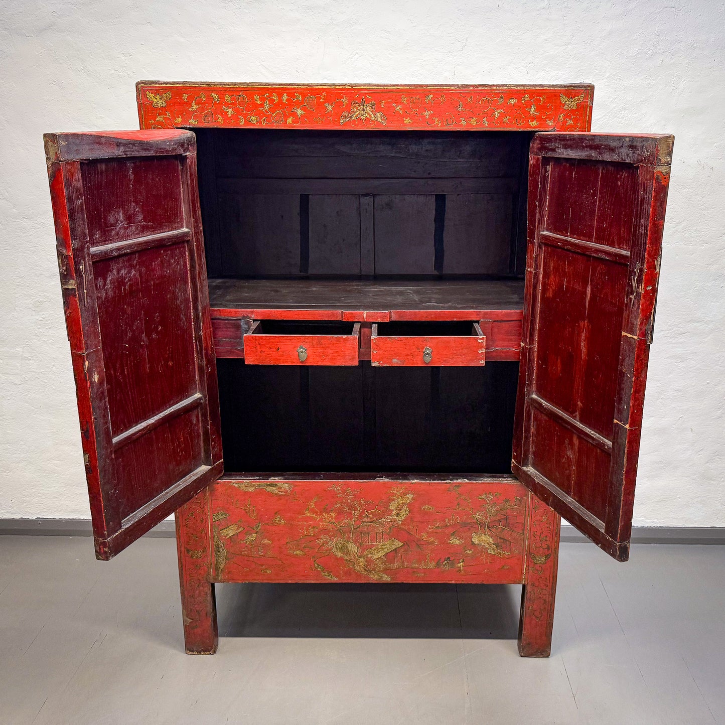 Red wooden cabinet with gold accents on a white background