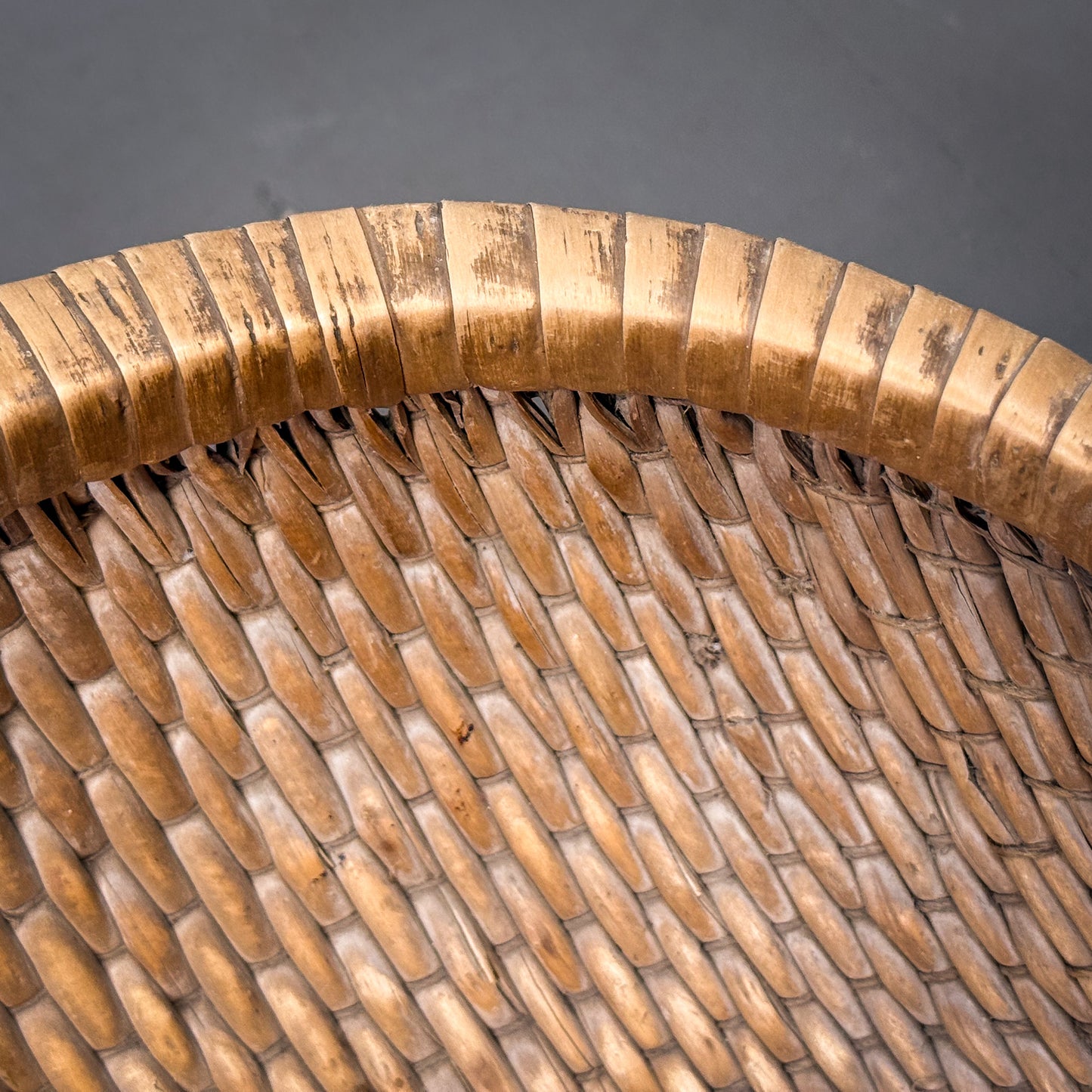 Close-up of a woven basket with a textured surface on a dark background