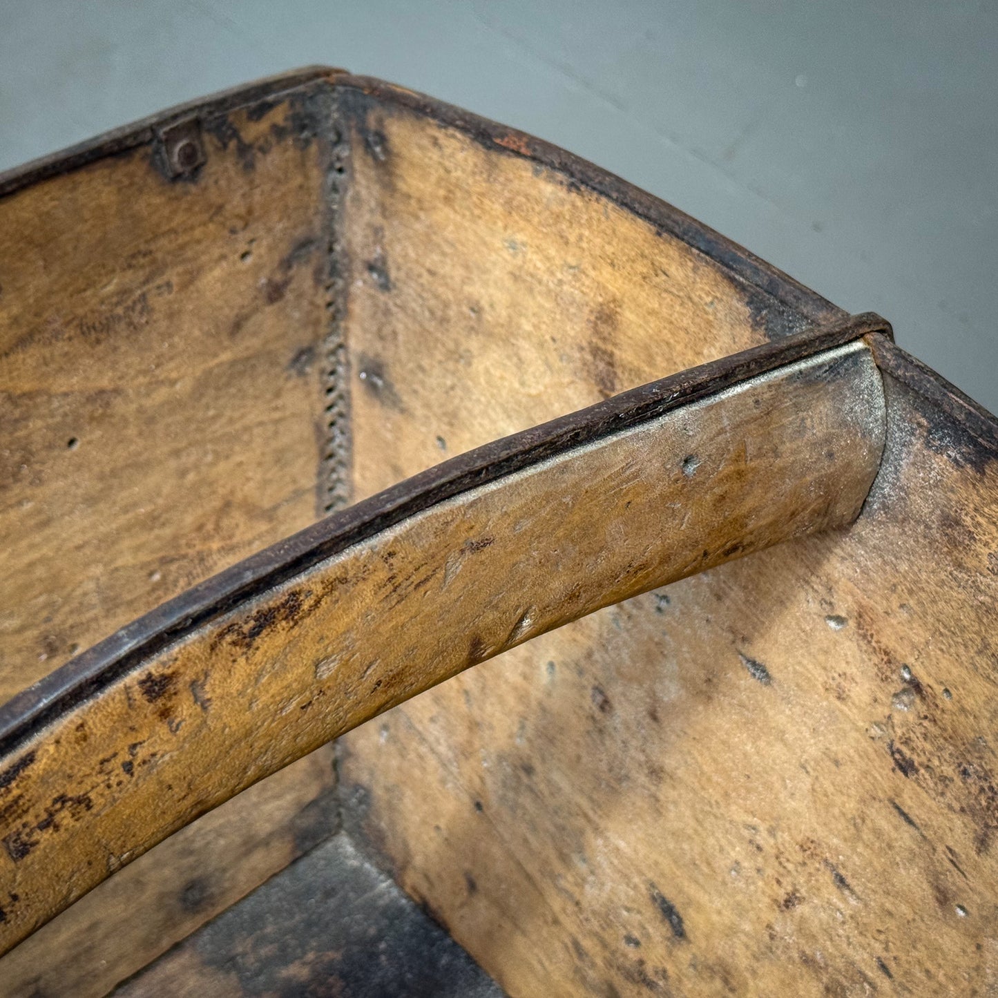 Close-up of a wooden box with metal corners on a gray background