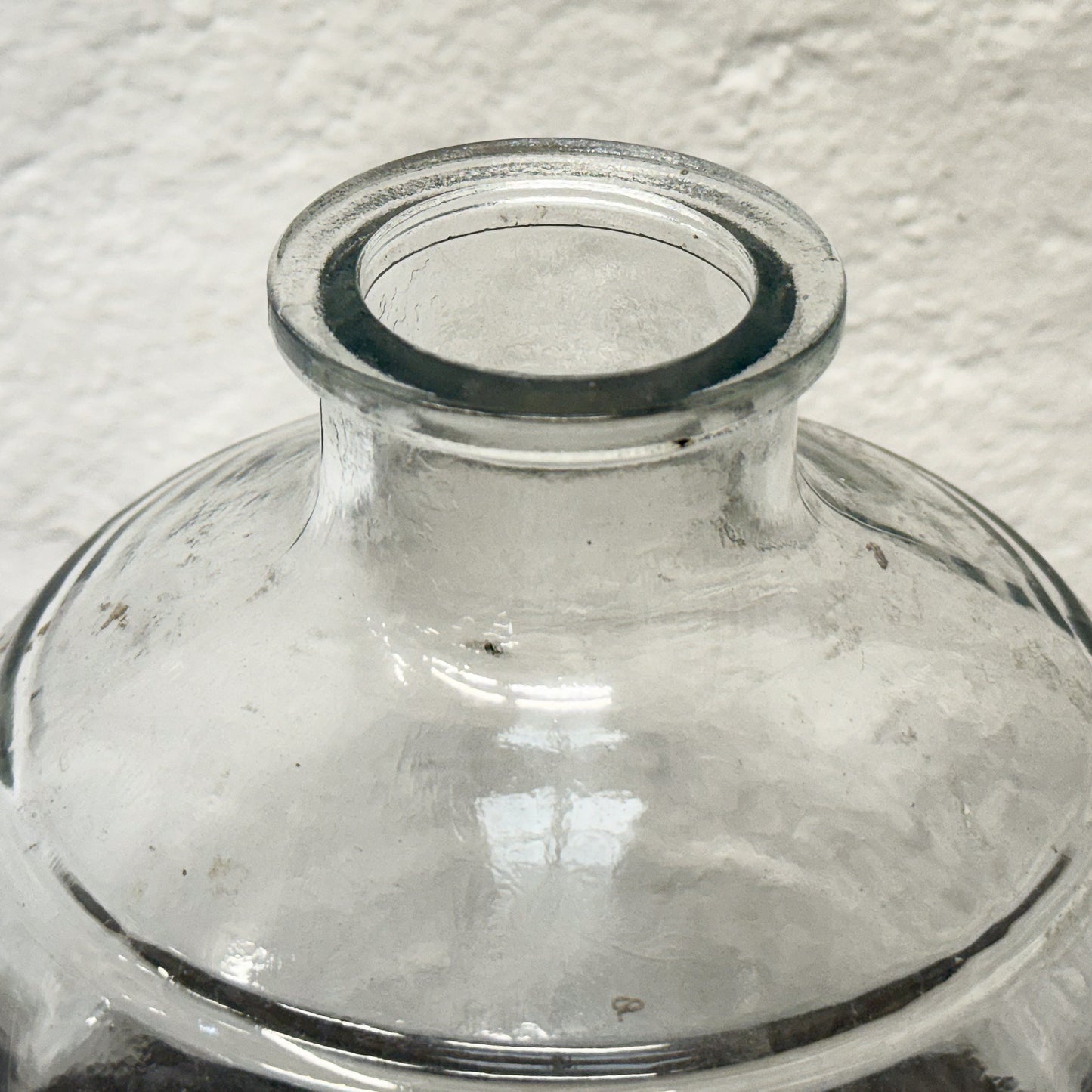 Clear glass vase on a textured white background