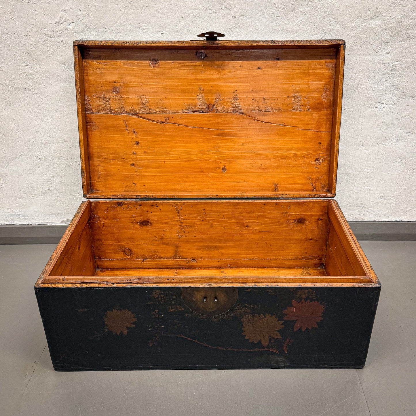 Wooden trunk with floral designs on a plain background