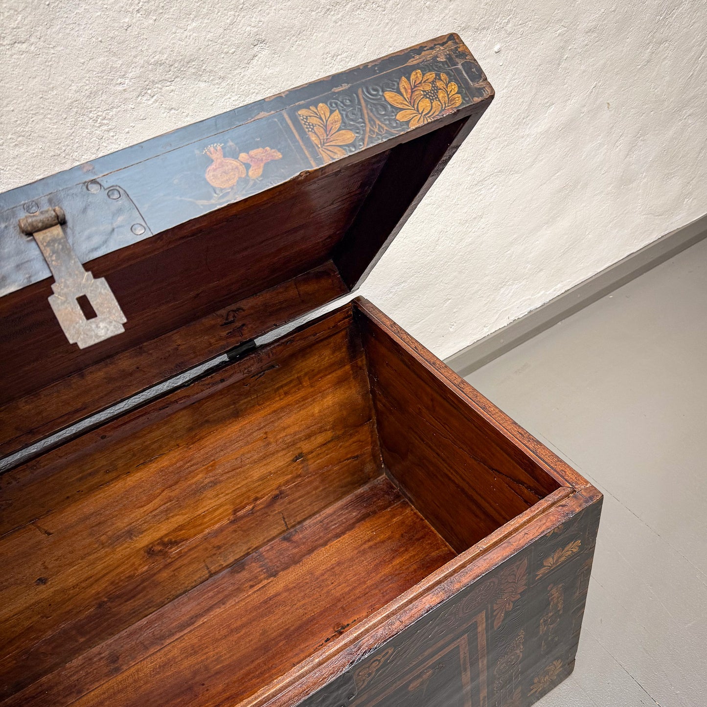 Wooden trunk with floral designs on a plain background