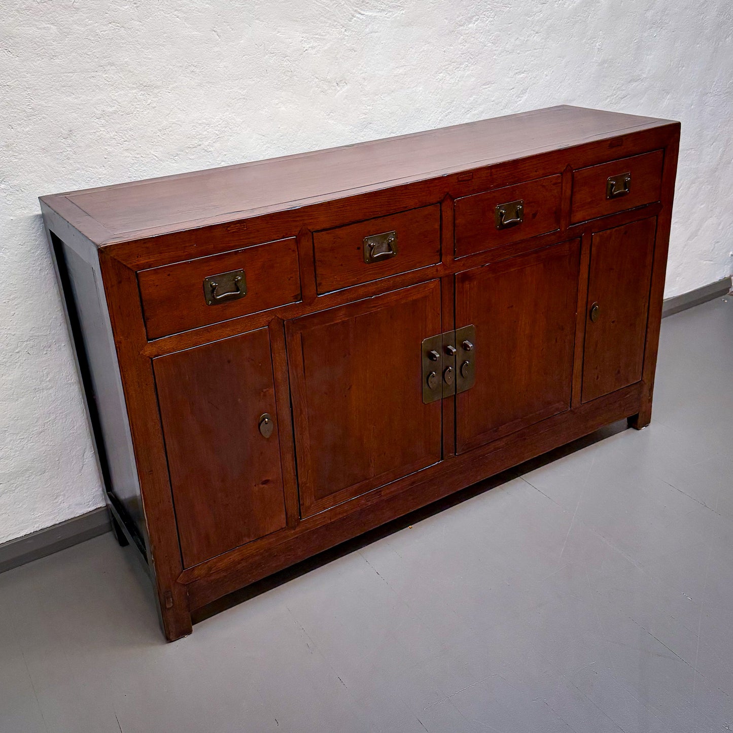 Wooden sideboard with brass handles on a plain background