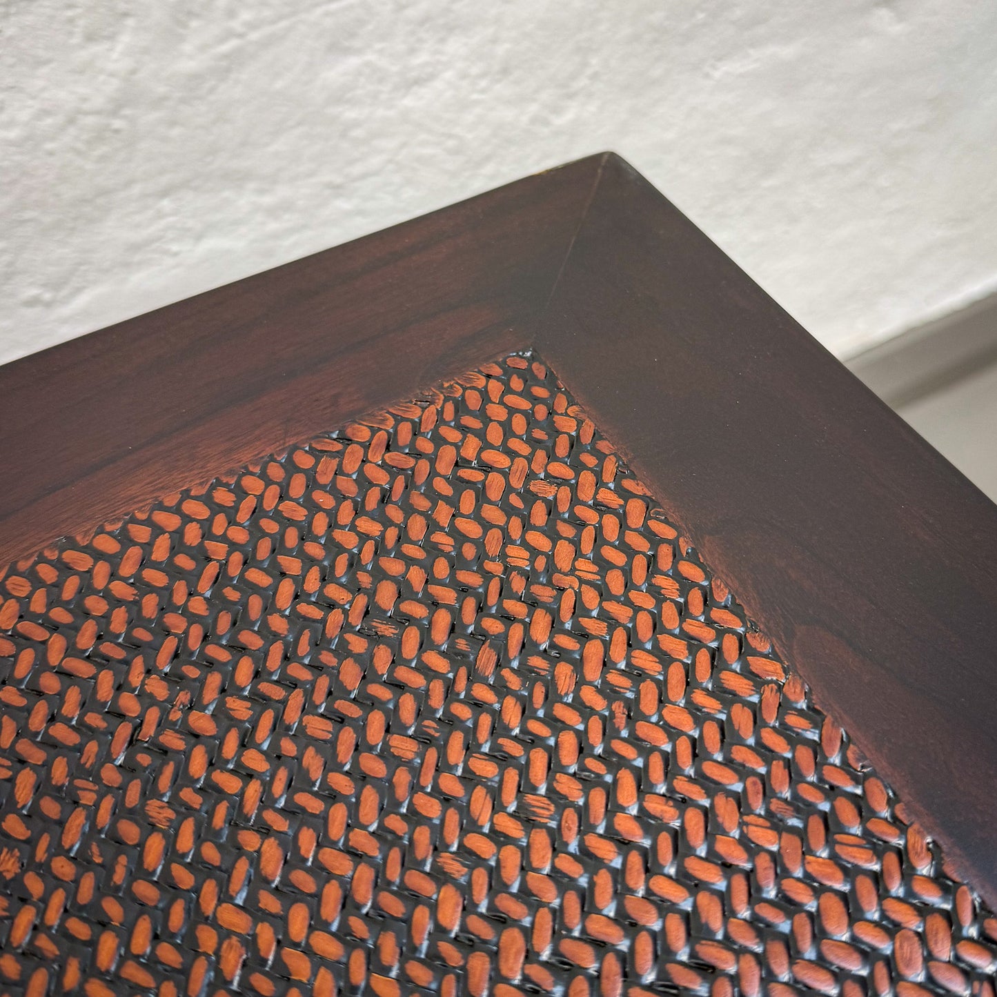 Textured brown mat with orange pattern on a wooden surface