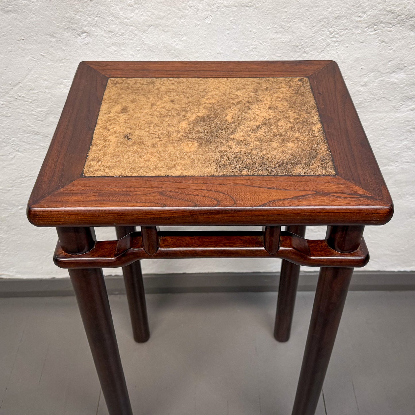 Wooden side table with a textured surface on a plain background