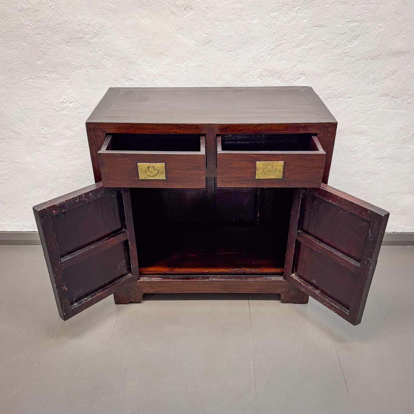 Wooden cabinet with open doors on a plain background
