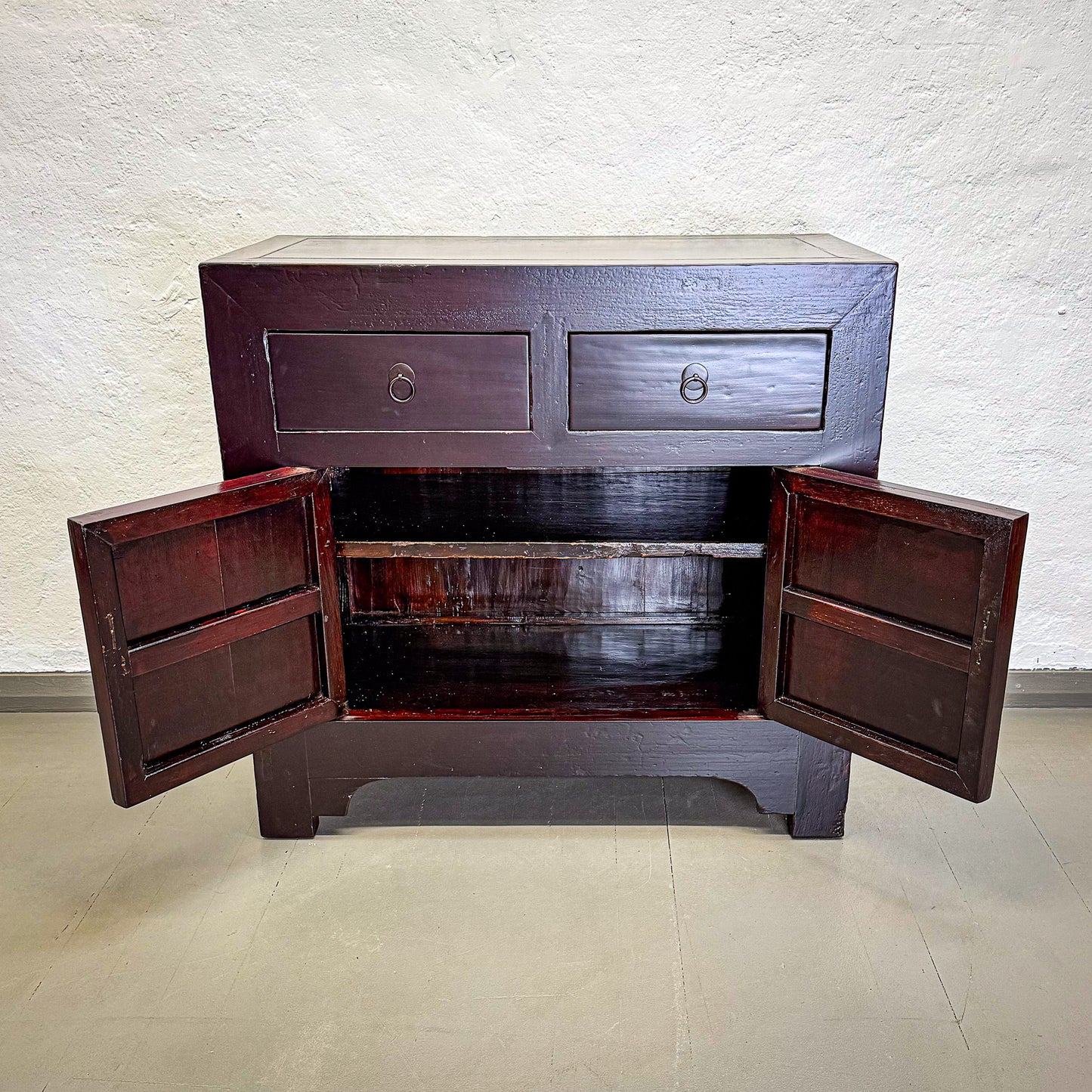 Wooden cabinet with open doors on a light background