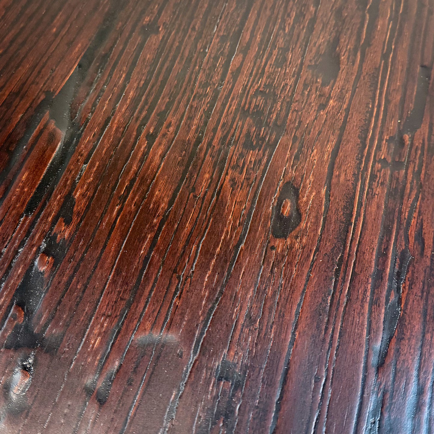 Close-up of a wooden surface with dark brown and black tones