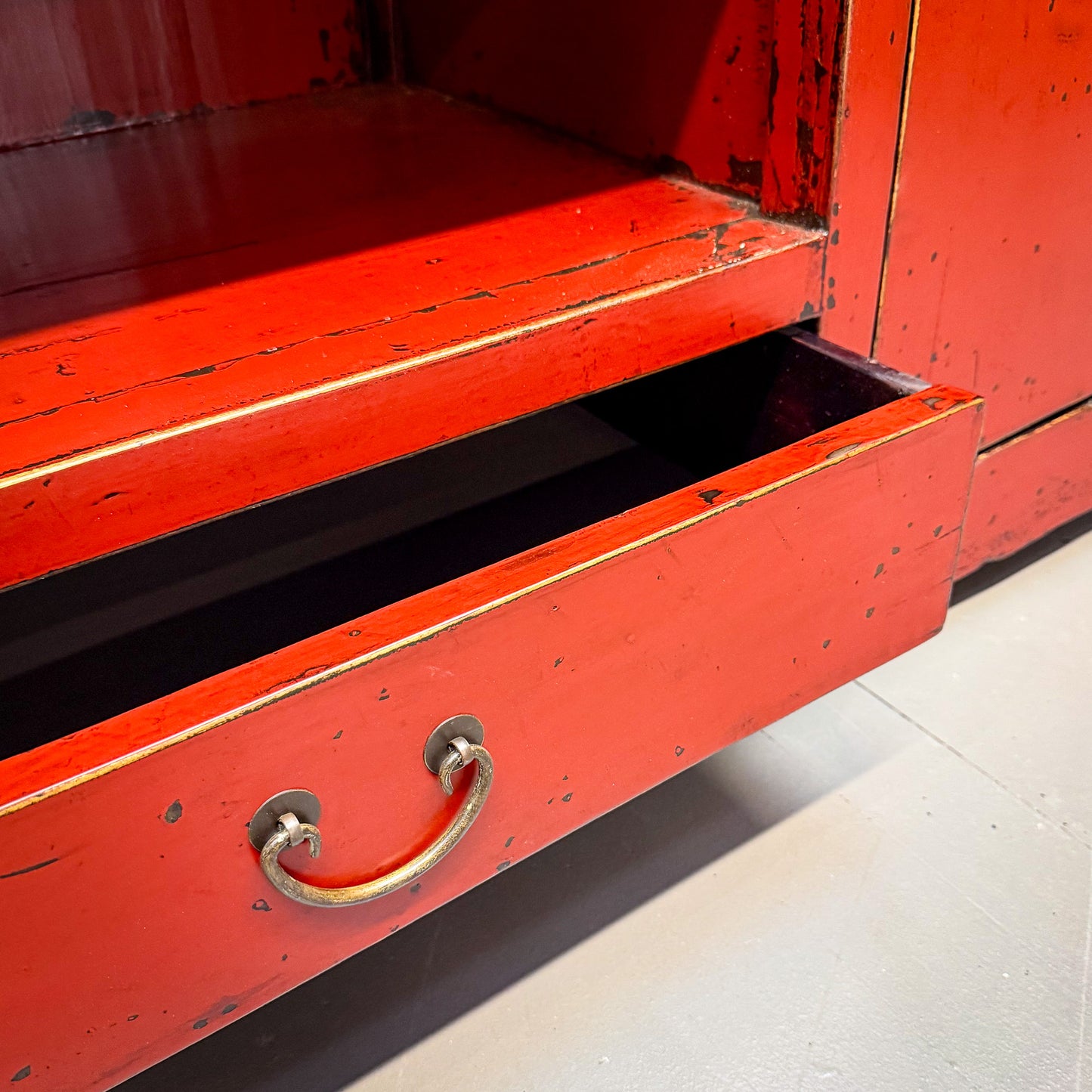 Red metal cabinet with a handle on a concrete floor