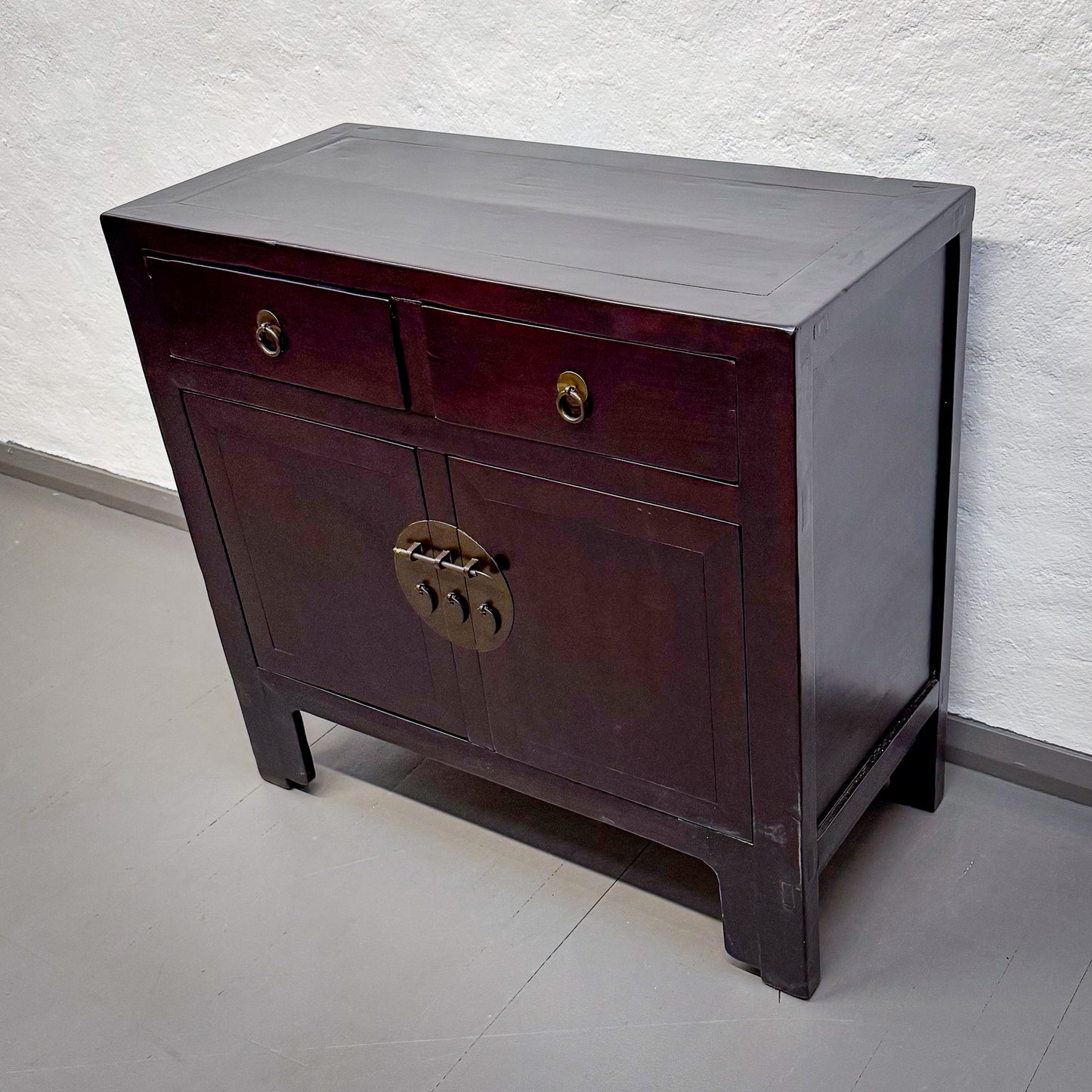 Wooden cabinet with a single drawer and a door on a plain background