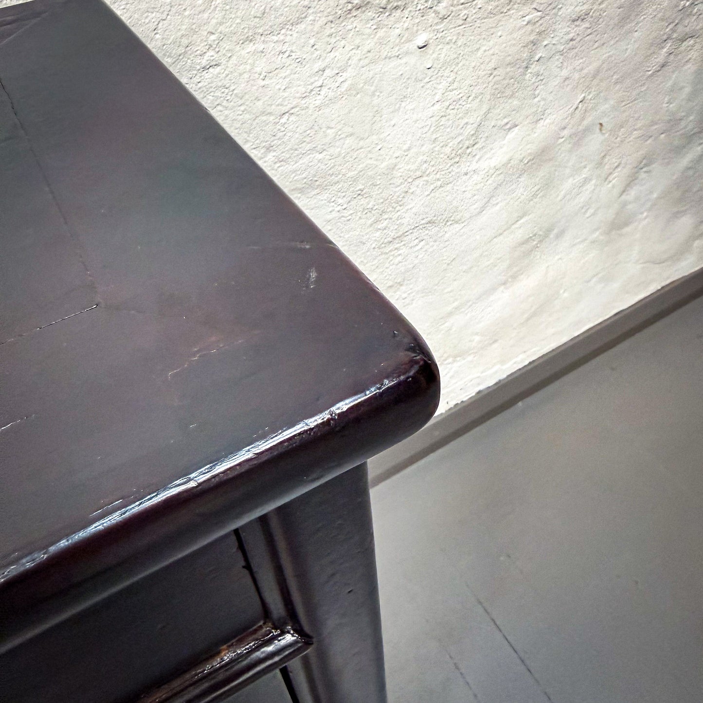 Dark wooden surface with a light gray wall in the background