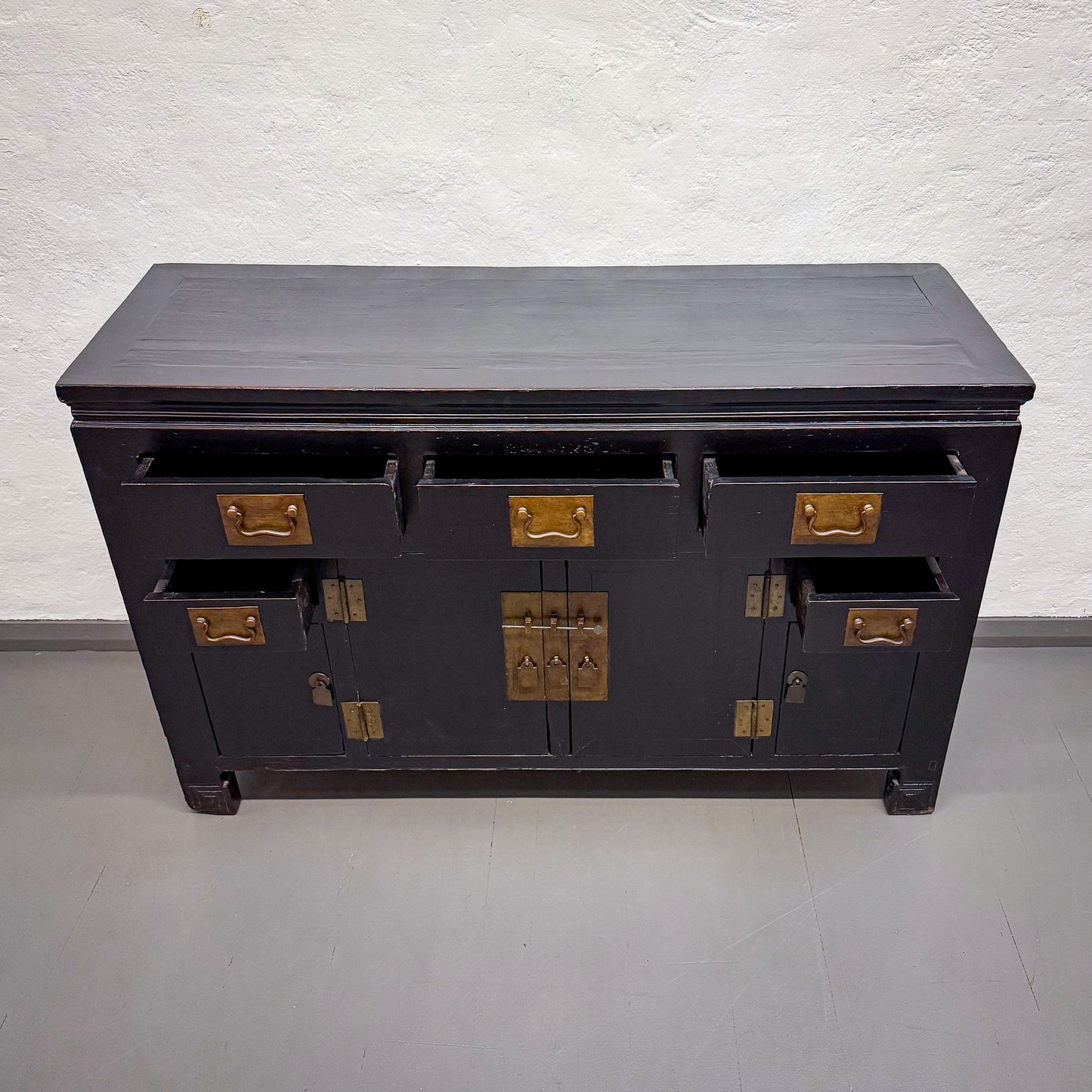 Black wooden cabinet with gold accents on a white background