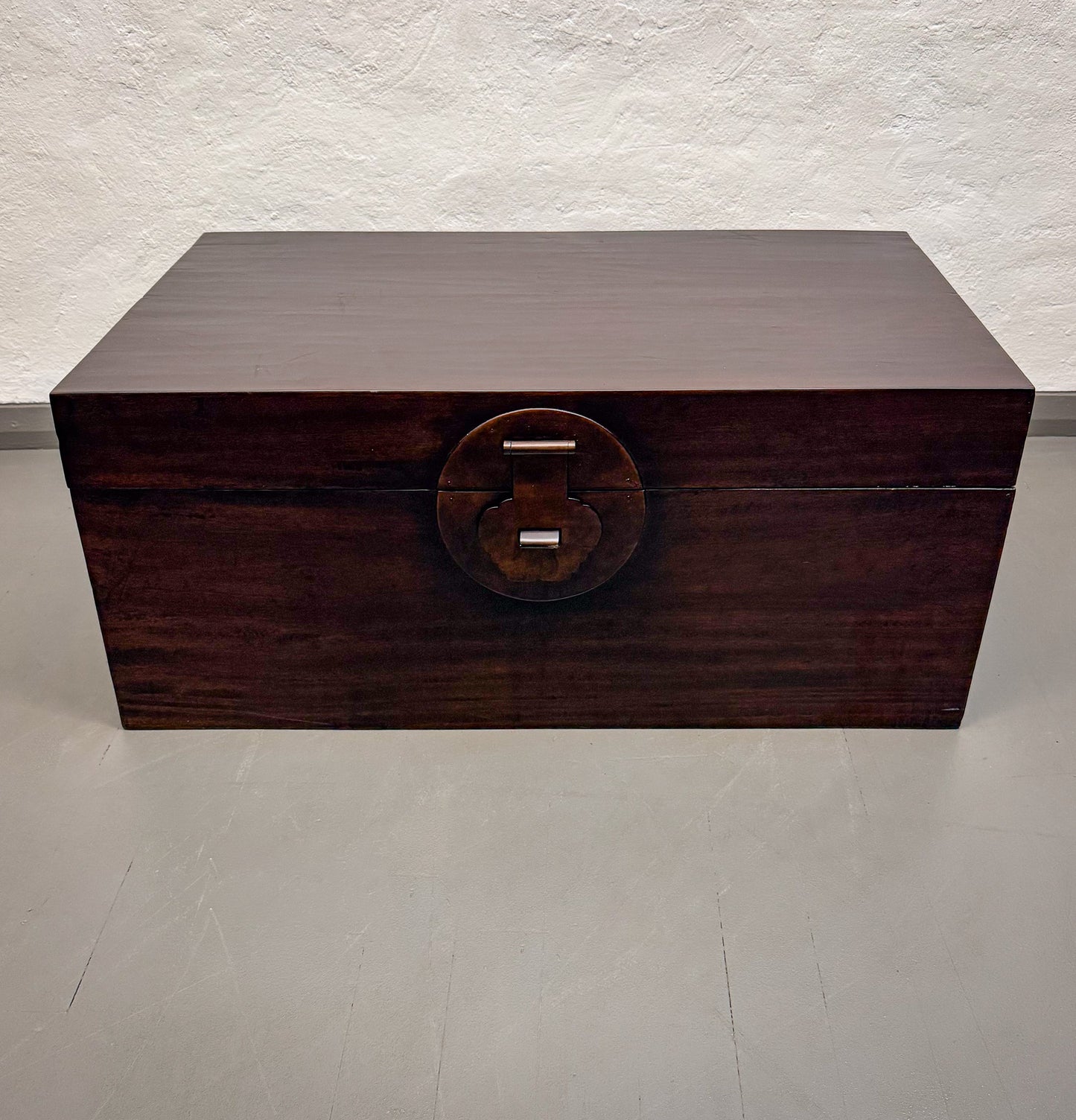 Wooden box with a circular handle on a light gray background