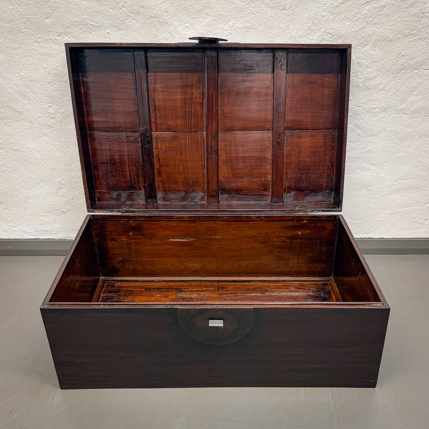 Wooden trunk with a hinged lid on a plain background