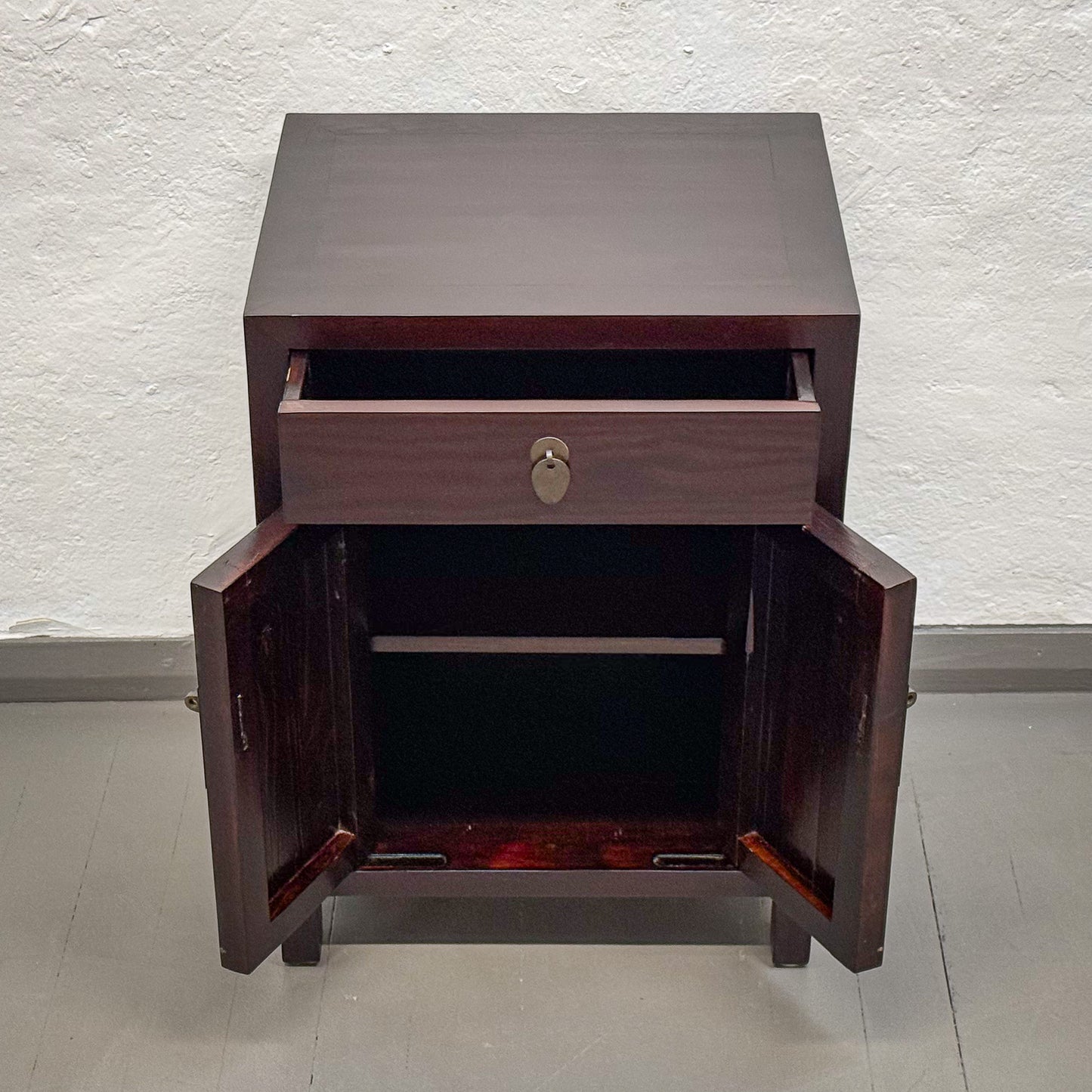 Wooden cabinet with open door on a plain background