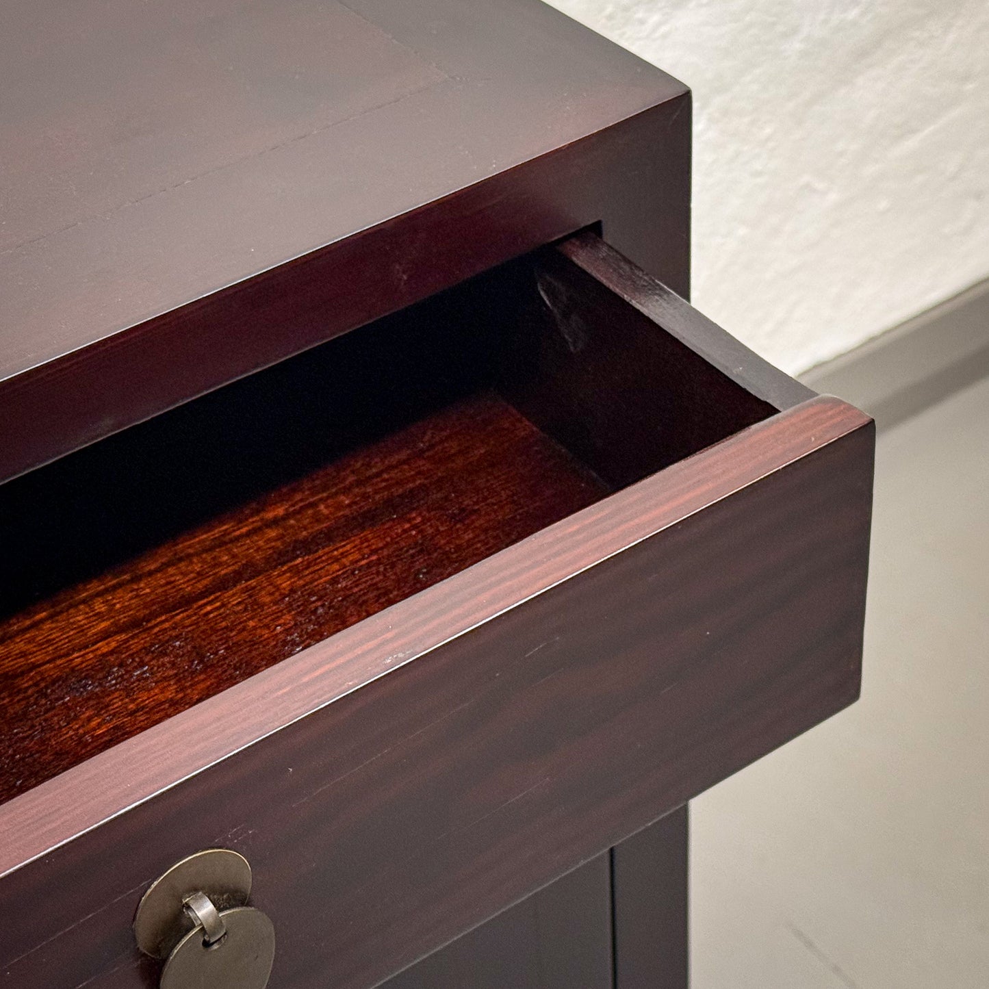 Wooden drawer being pulled out from a cabinet with a neutral background