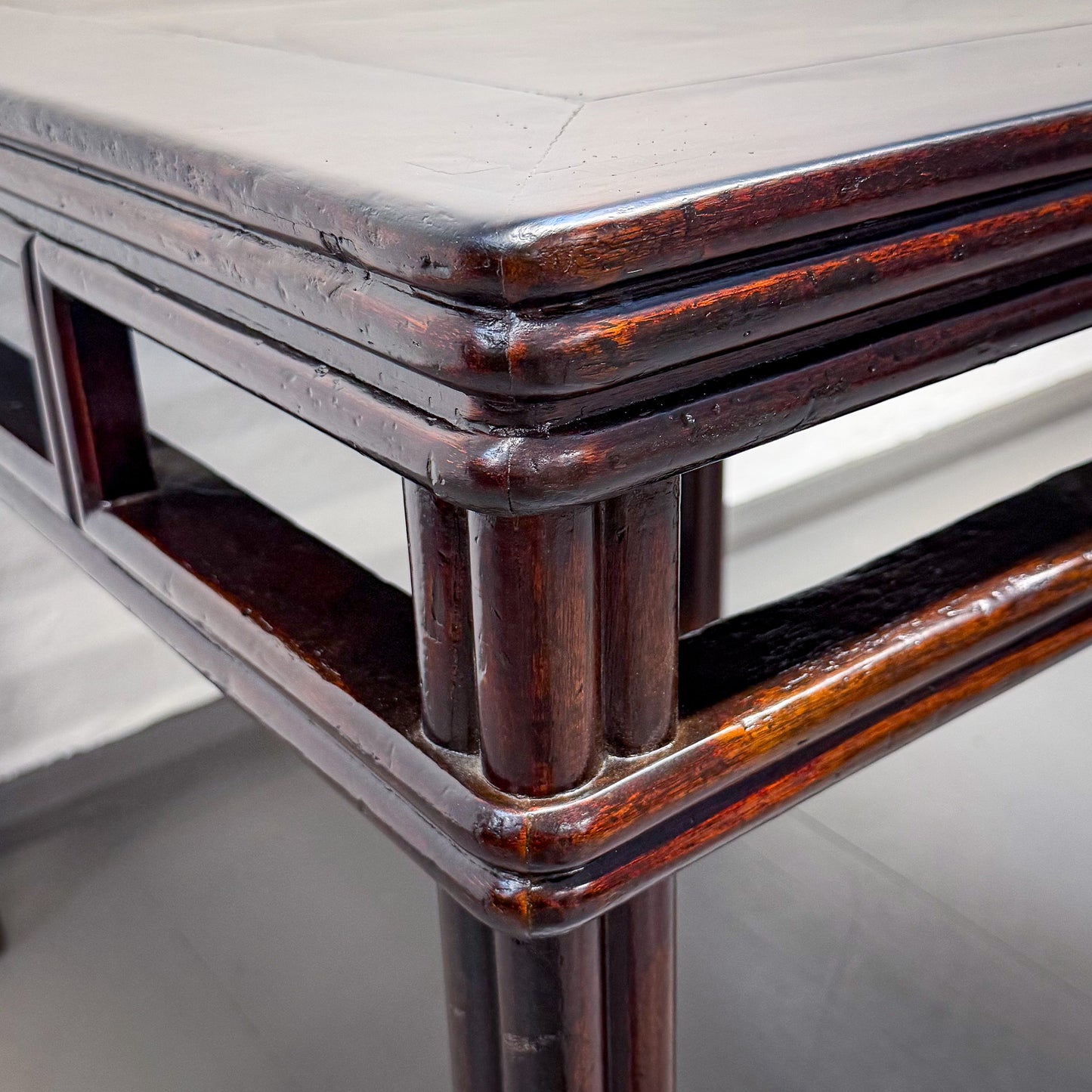 Close-up of a wooden table corner with a reflective surface