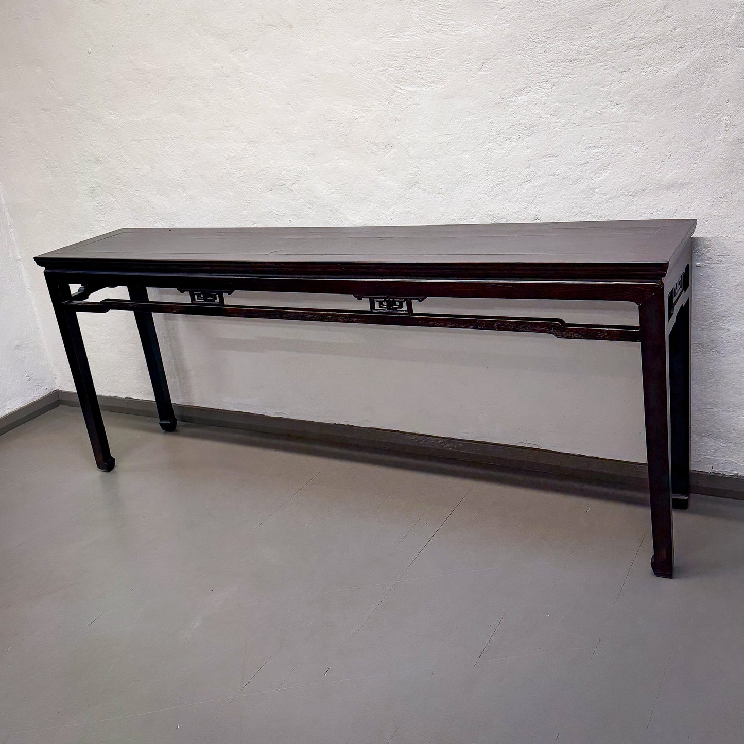 Dark wooden table against a white textured wall