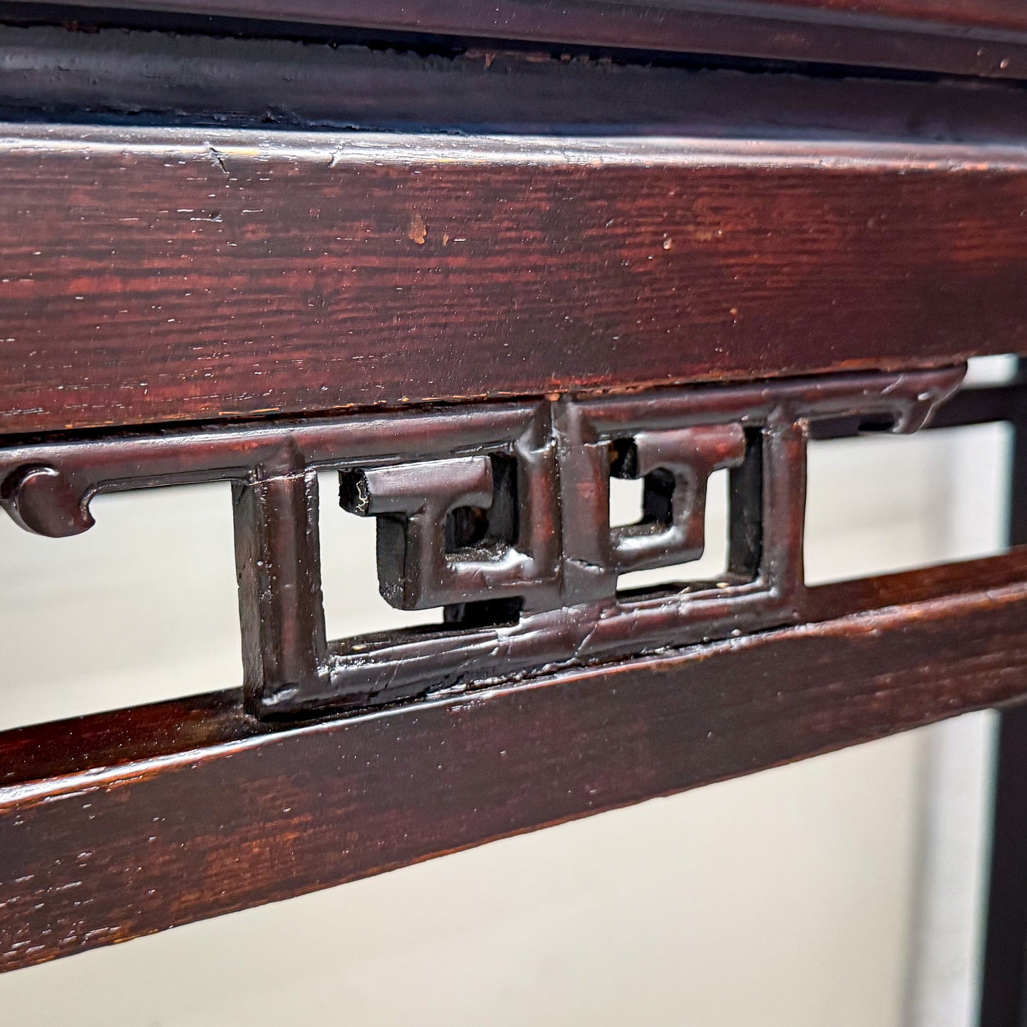Close-up of a wooden frame with intricate carvings on a white background
