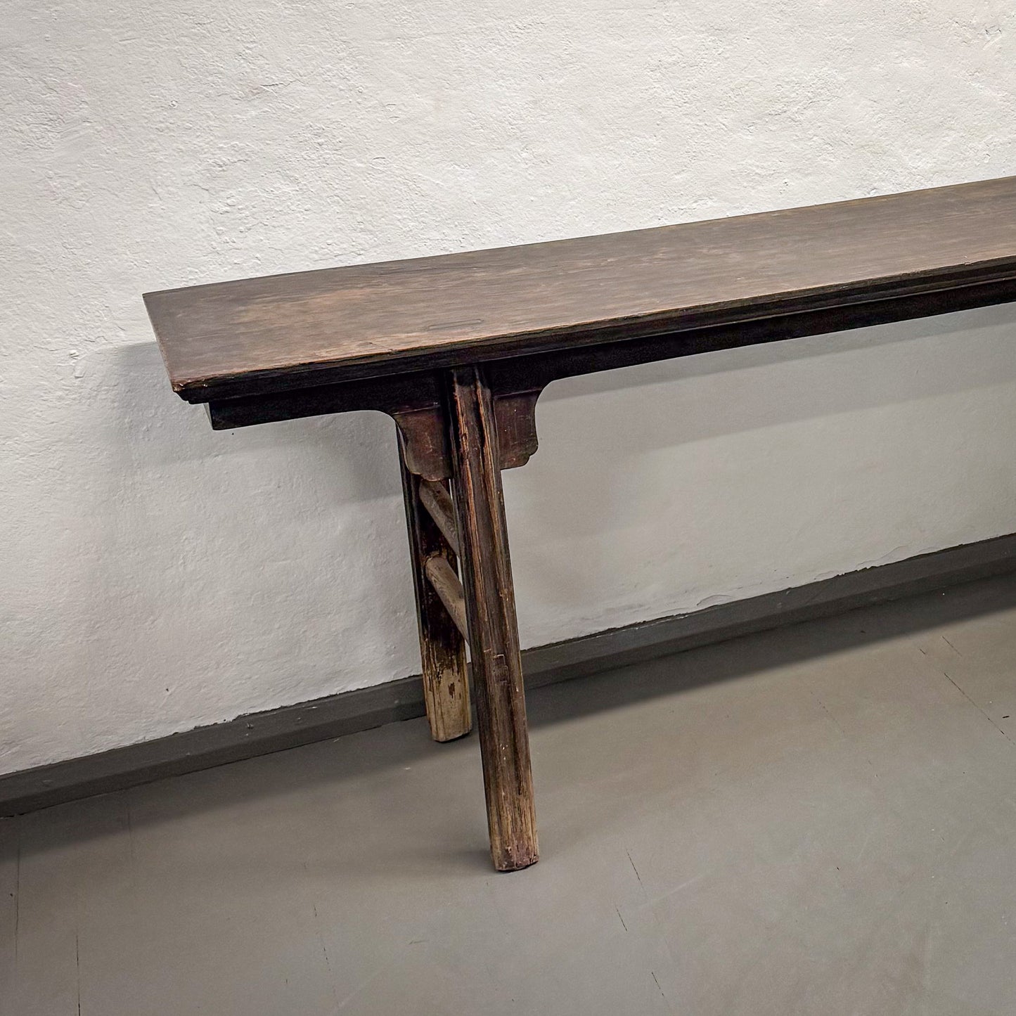 Old wooden table against a plain wall