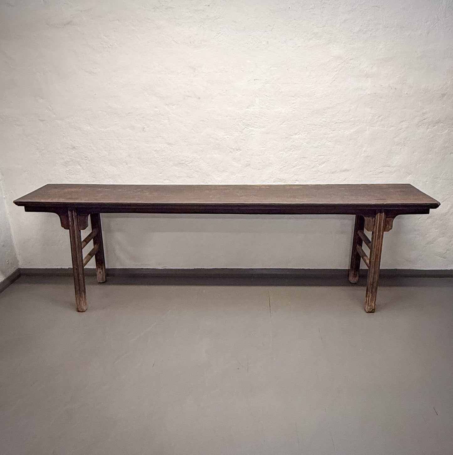 Wooden table against a white brick wall
