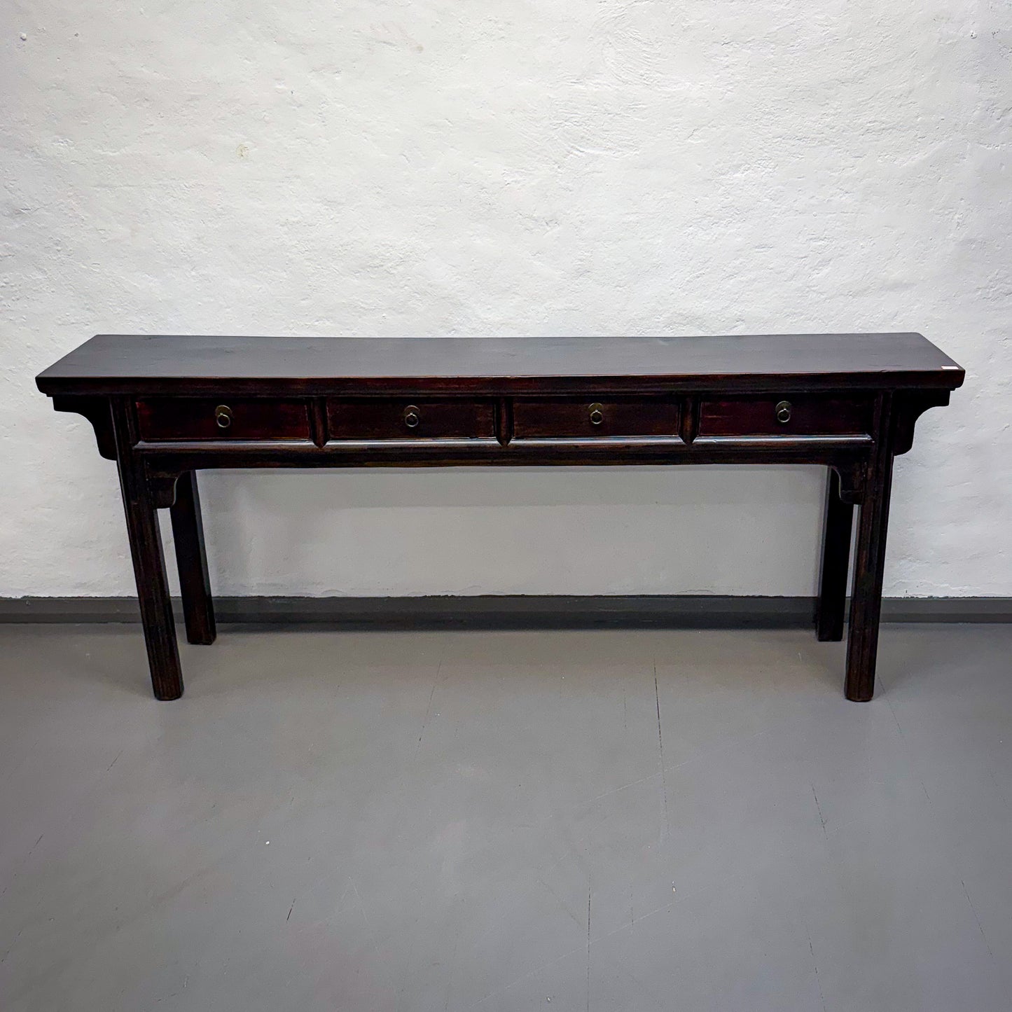 Dark wooden console table against a white wall