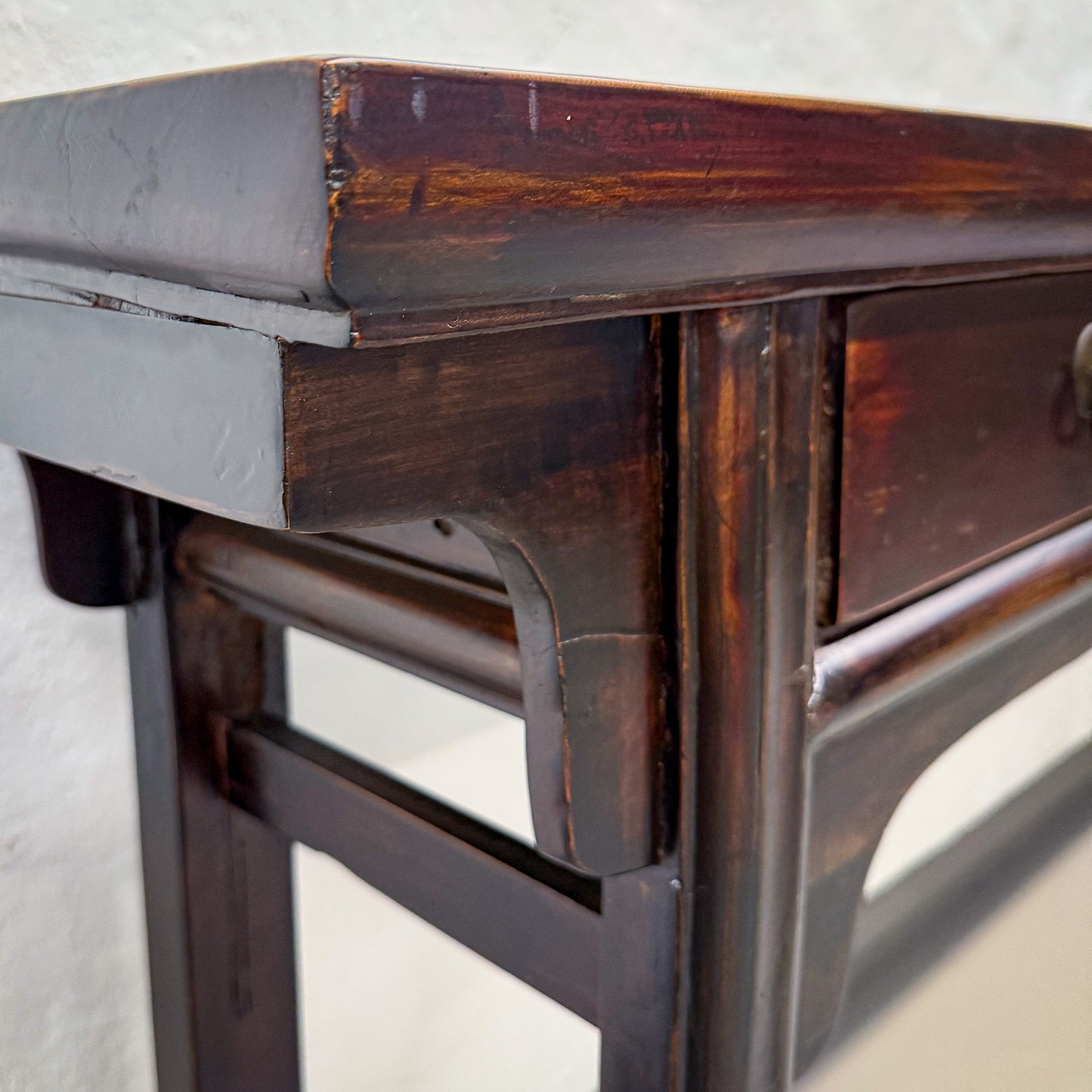 Close-up of a wooden table with metal legs on a light background